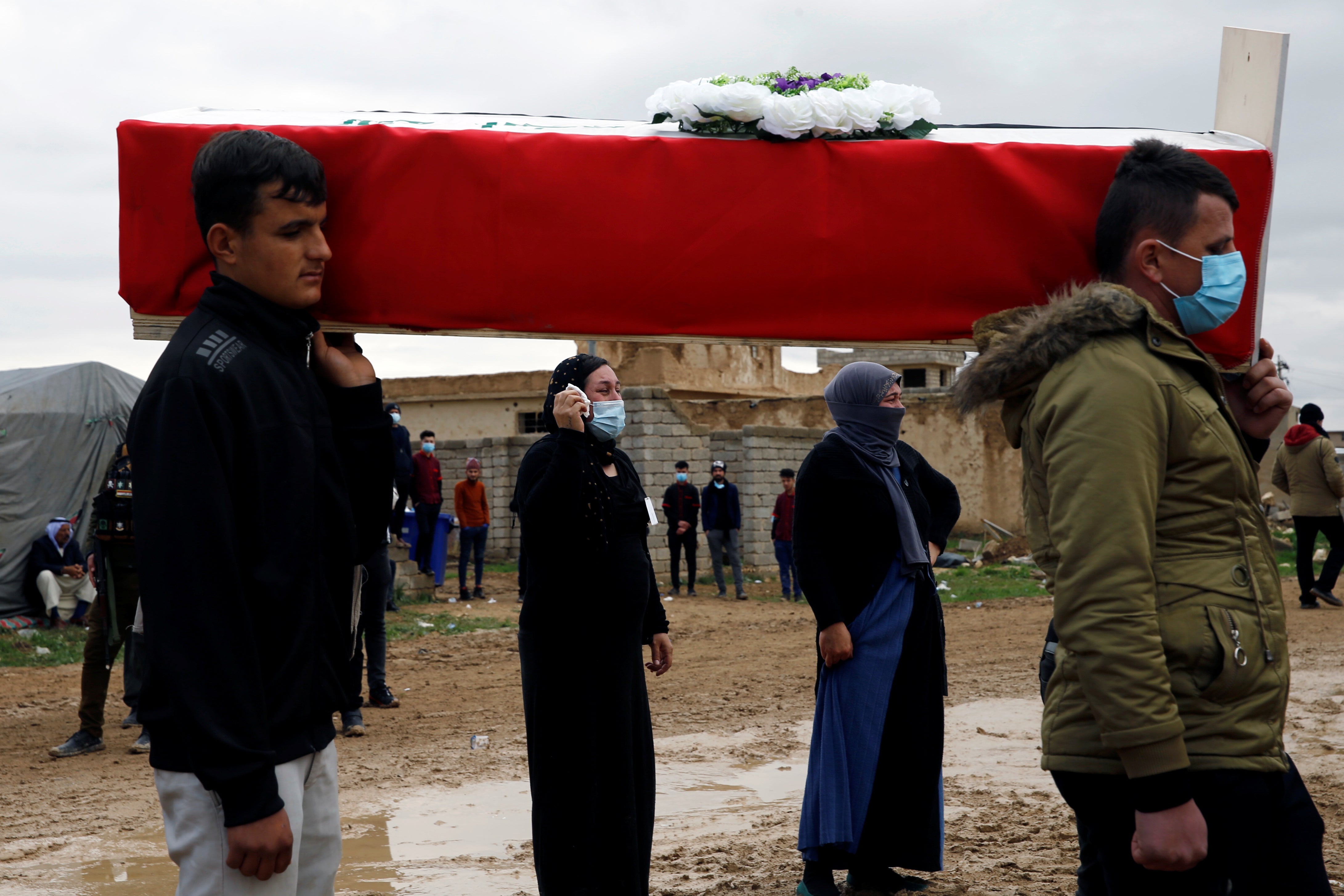 Yazidis women react during the funeral of those killed by the Islamic State