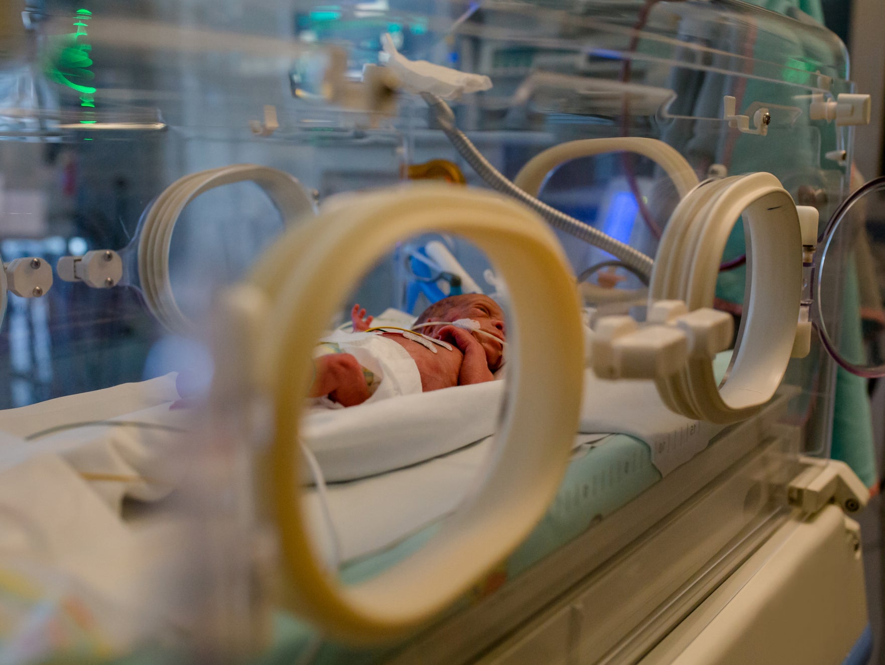 A newborn baby in an incubator at hospital