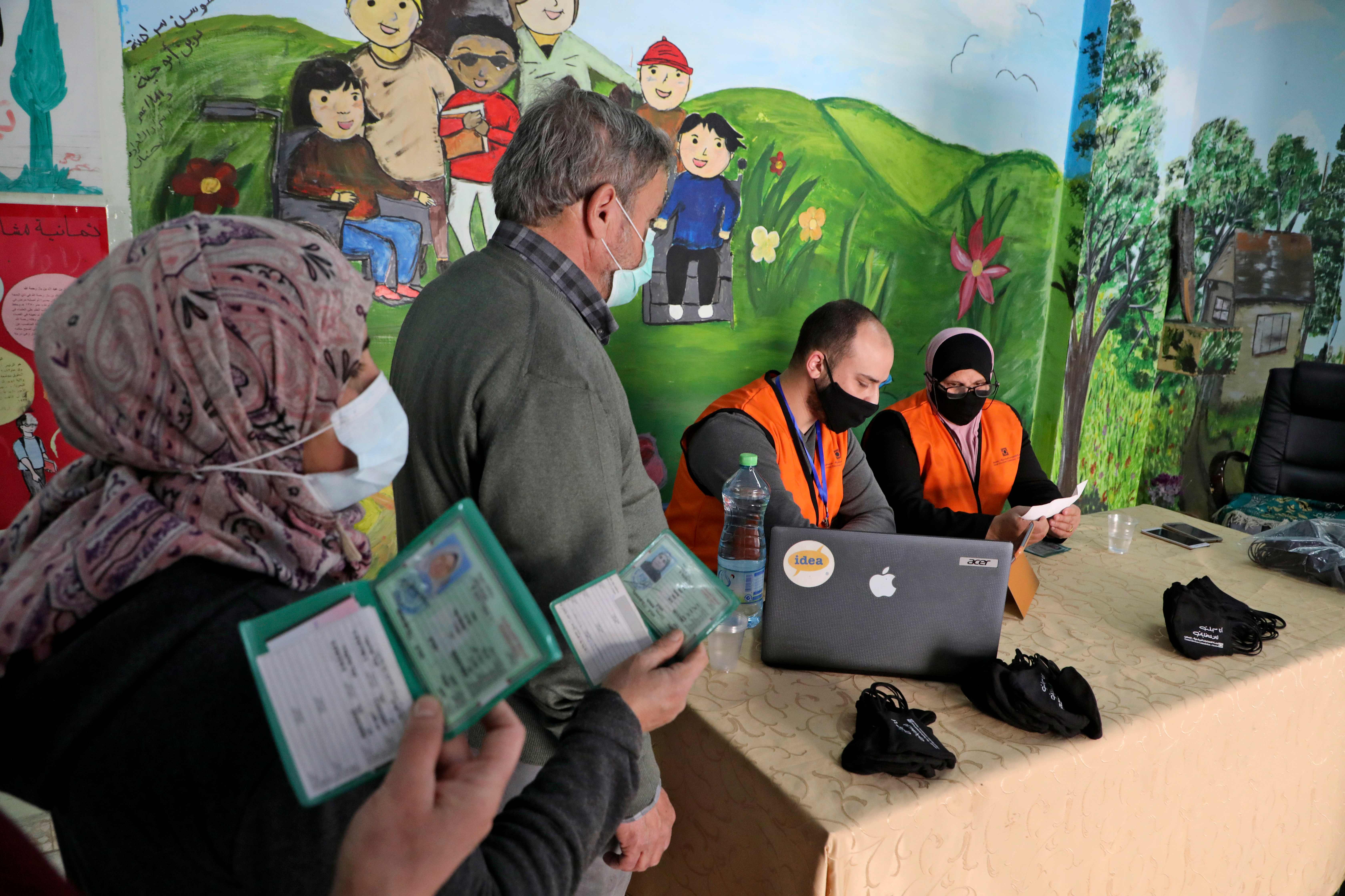 Members of the Palestinian Central Elections Commission register voters in the West Bank town of Hebron