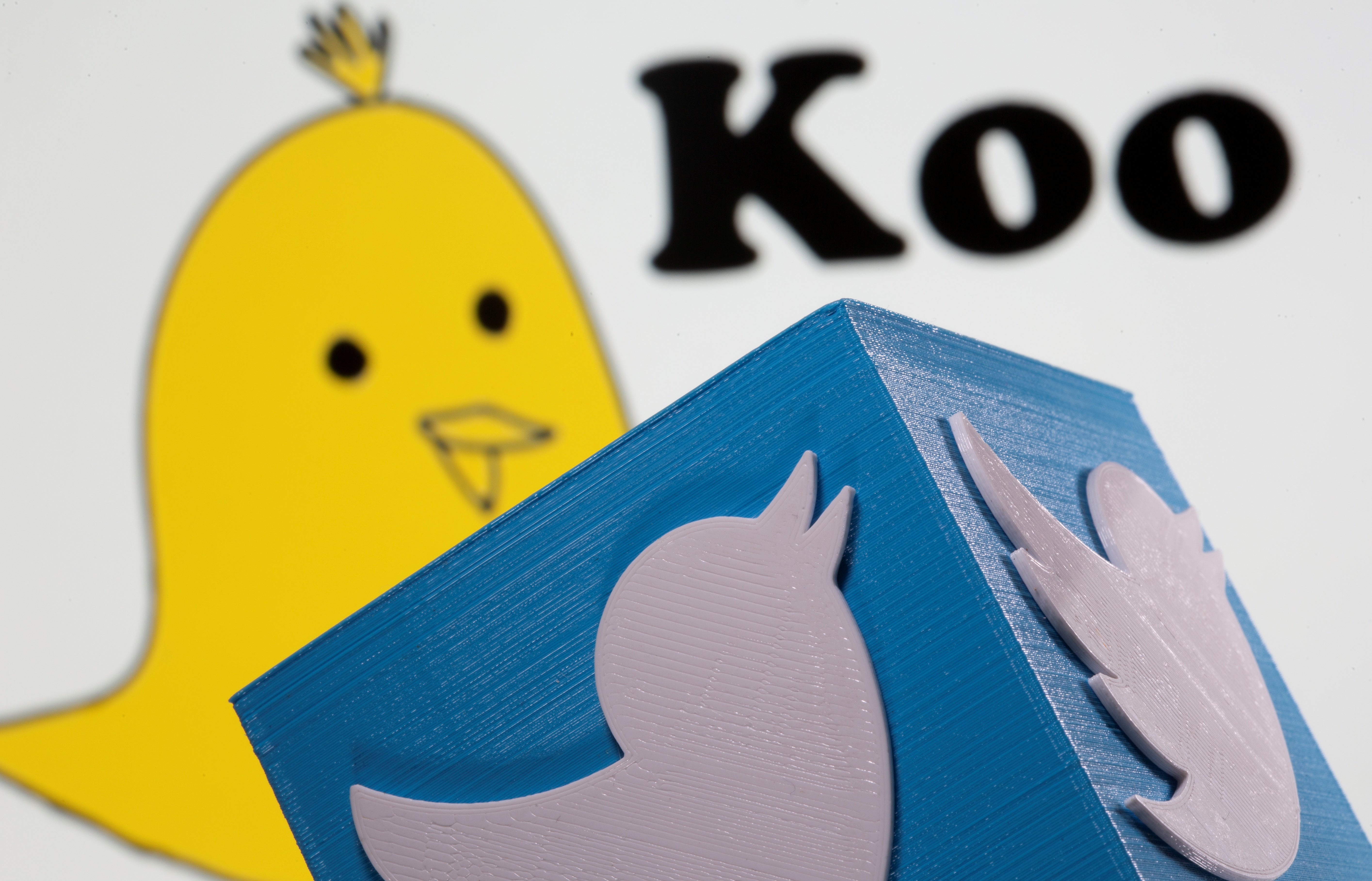 <p>A 3d printed Twitter logo is seen in front of the Koo app's logo</p>