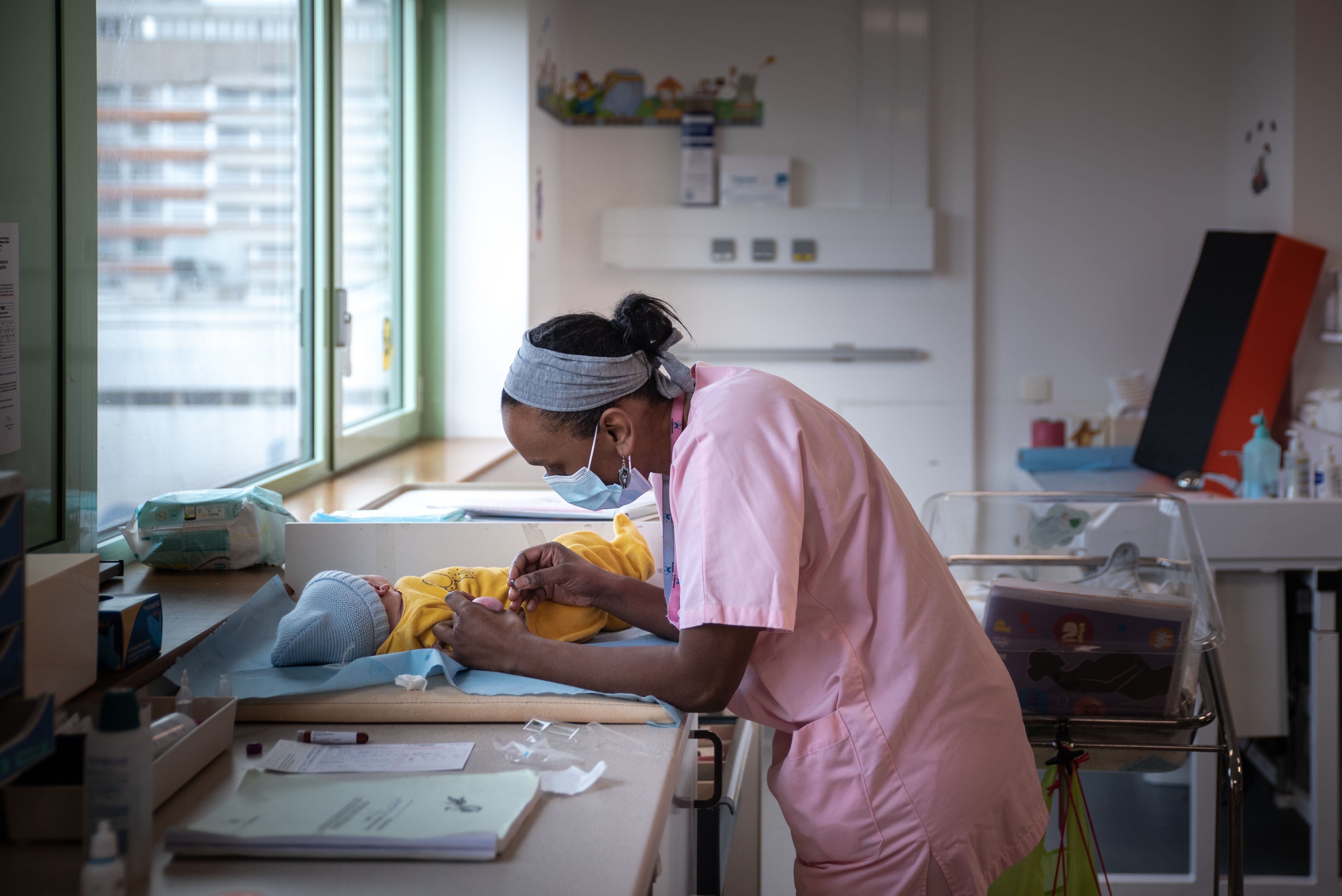 A midwife attends to a newborn baby at a hospital in Saint-Denis, Paris, in February