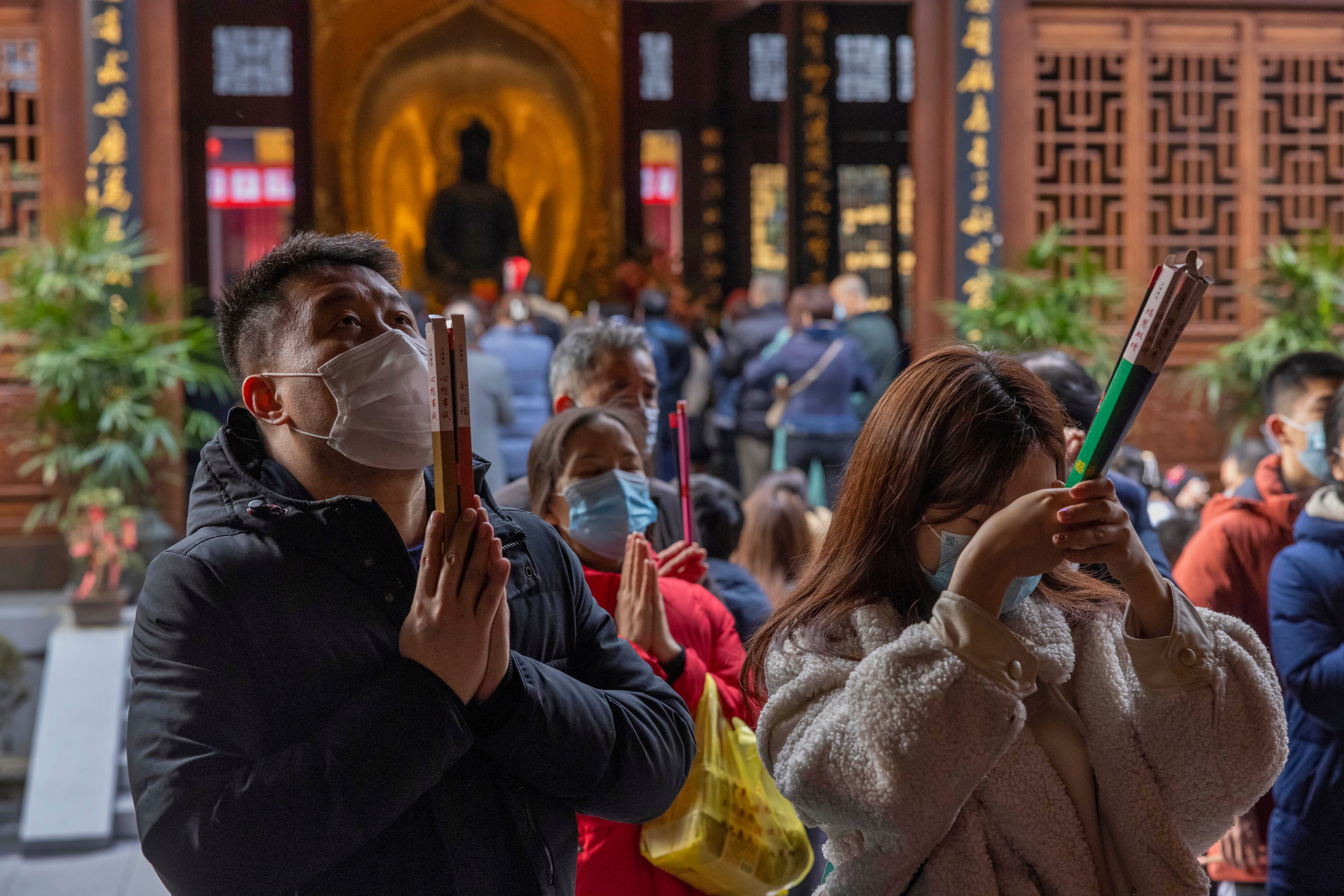 People burn incense sticks and pray at Jade Buddha Temple in Shanghai