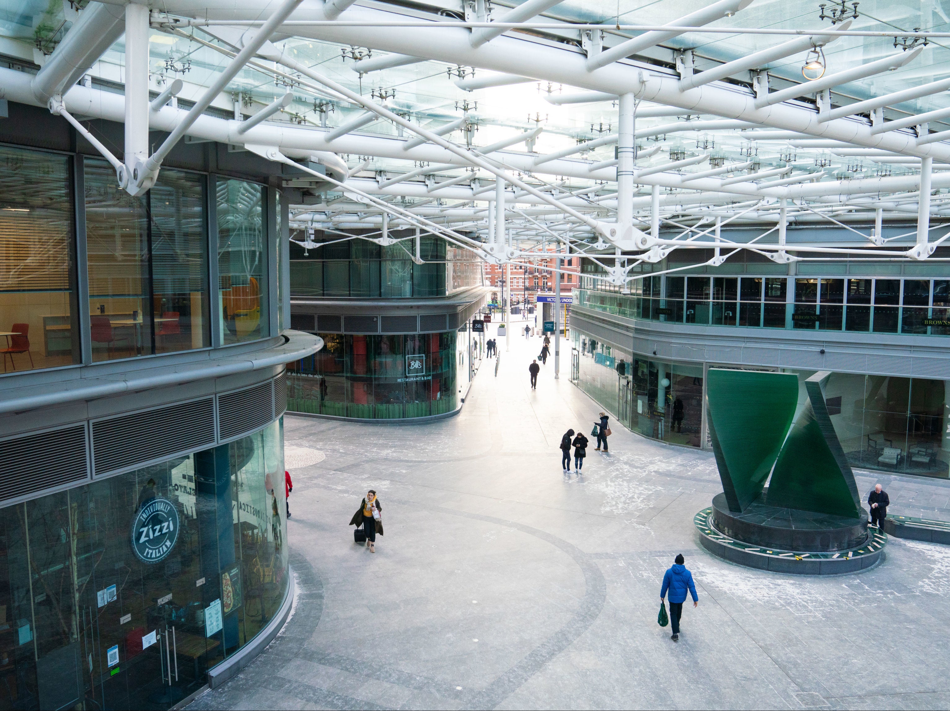 People walk through a largely empty shopping centre in Victoria, central London