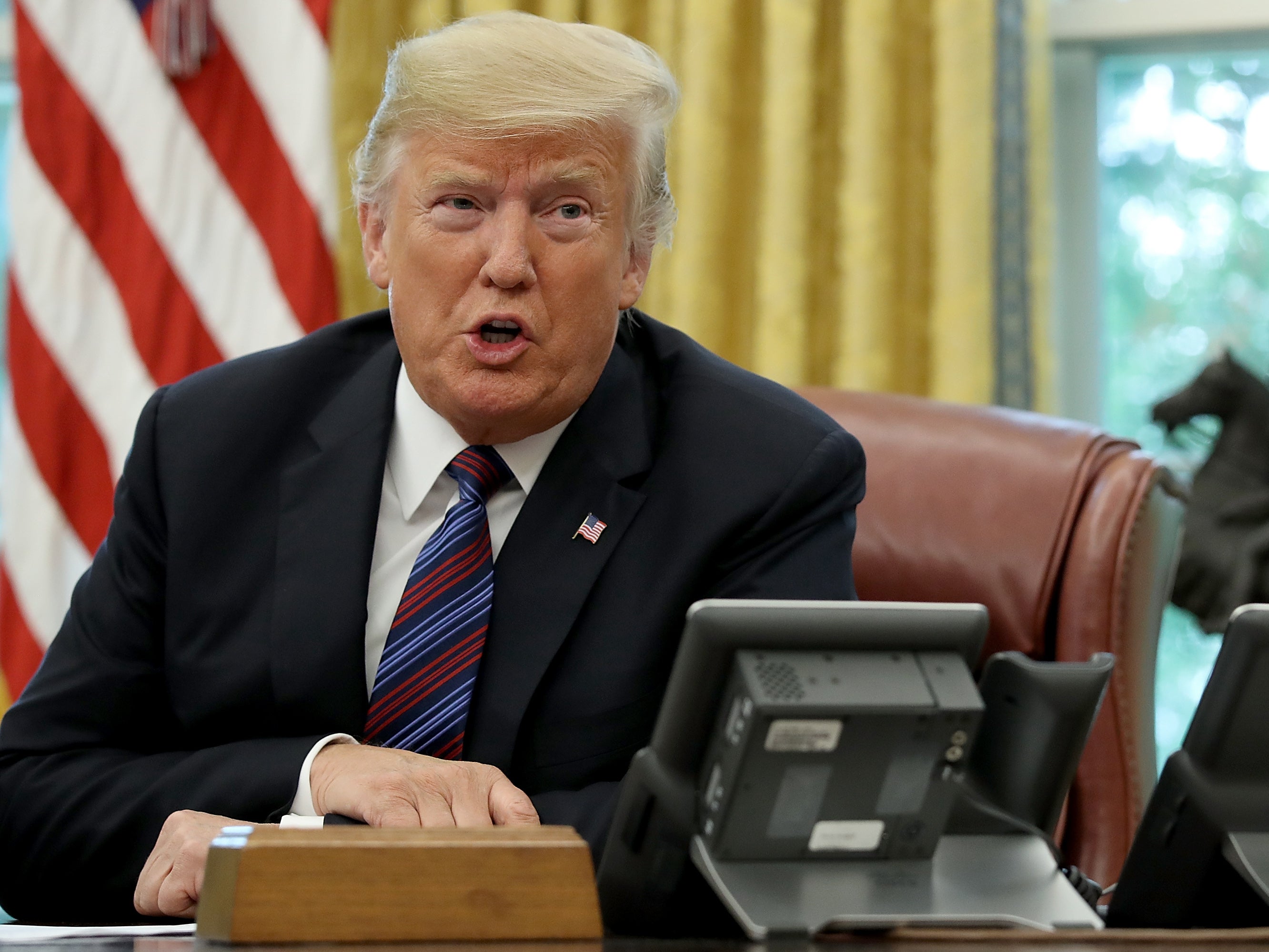 <p>Donald Trump speaks on the telephone via speakerphone with Mexican President Enrique Peña Nieto in the Oval Office of the White House on 27 August 2018 in Washington, DC</p>