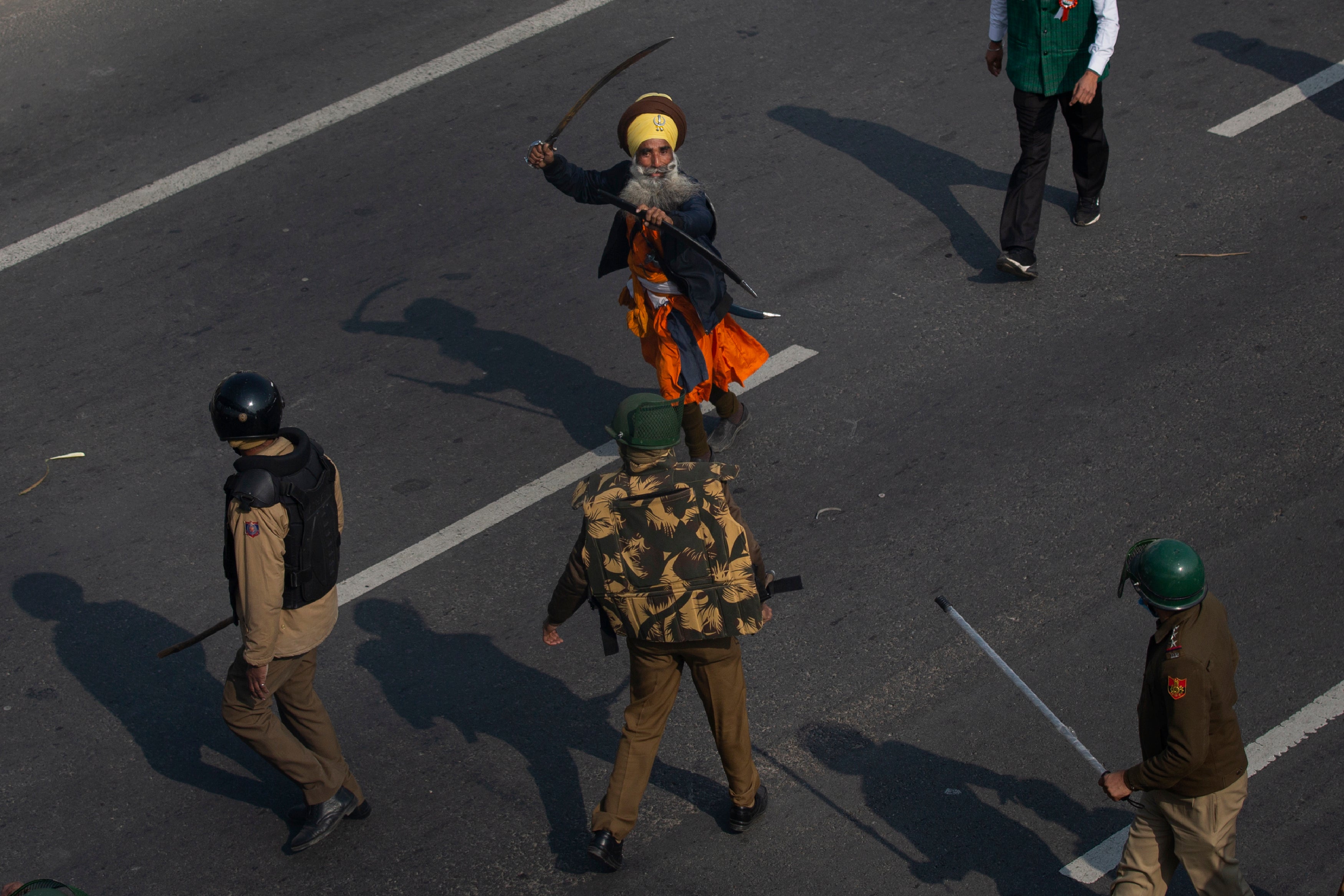 In this January 2021 photo, a Nihang brandishes a sword at policemen as protesting farmers march to the capital breaking police barricades during India's Republic Day celebrations in New Delhi