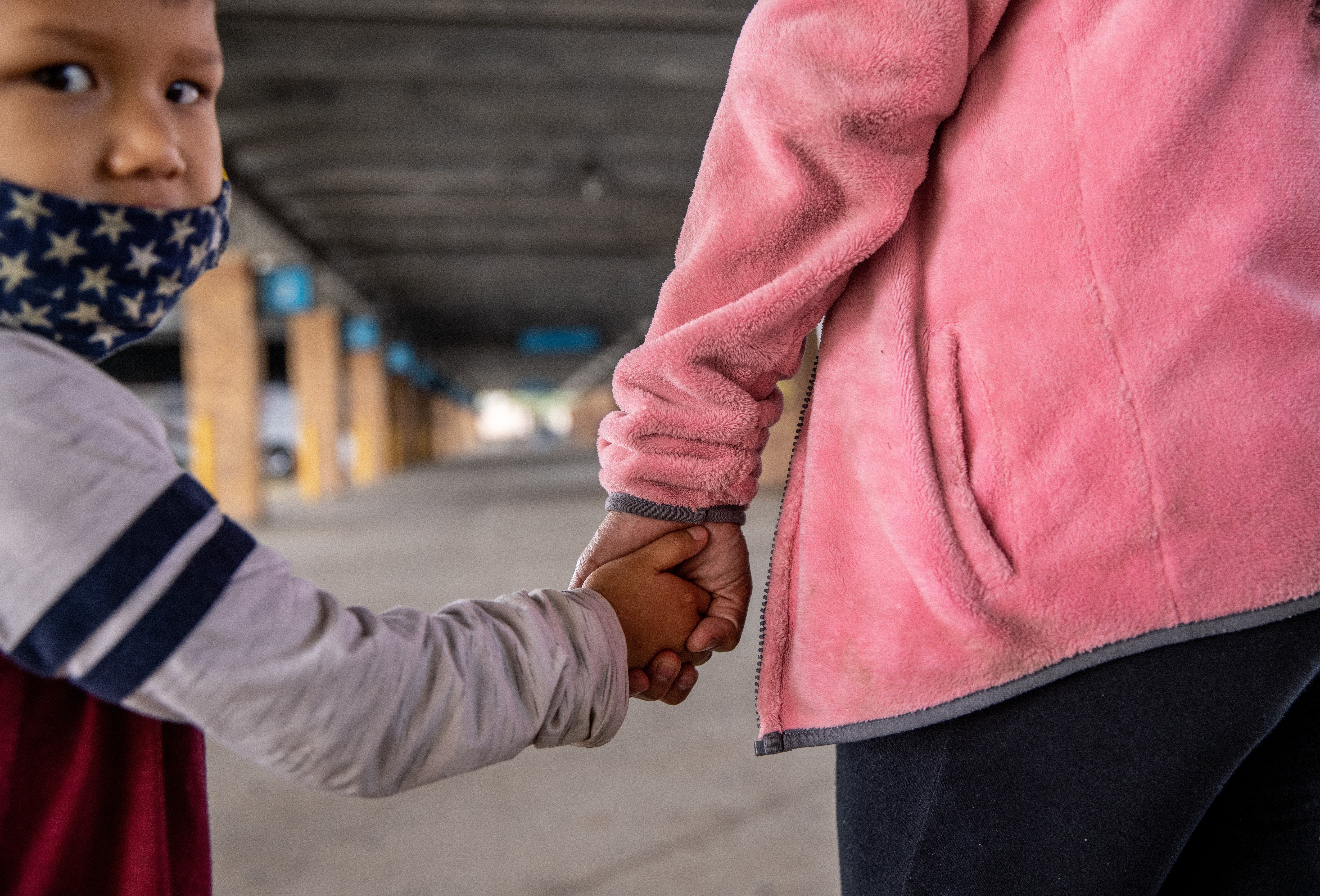 Asylum seekers from Honduras wait at a bus station after they were released from US immigration authorities on 8 February, 2021 in Brownsville, Texas. Asylum seekers are being released to stay in the US again as President Joe Biden works  to reverse the Trump administration’s ‘Remain in Mexico’ policy.