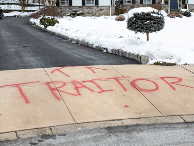<p>Graffiti is spray painted on the driveway outside of attorney Michael van der Veen’s suburban Philadelphia home, Saturday on 13 February 2021</p>