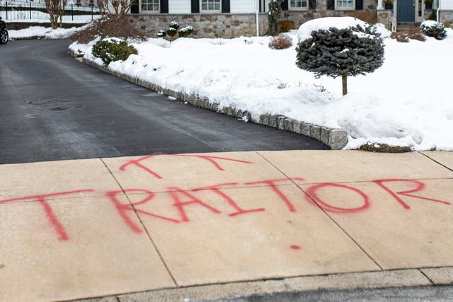 <p>Graffiti is spray painted on the driveway outside of attorney Michael van der Veen’s suburban Philadelphia home, Saturday on 13 February 2021</p>