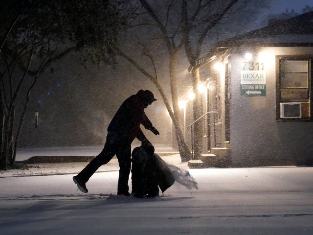 <p>Two people play in the snow in San Antonio, on 14 February 2021</p>