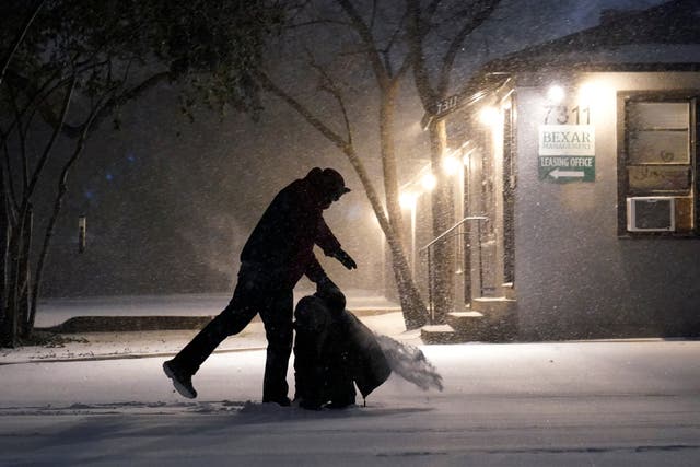 <p>Two people play in the snow in San Antonio, on 14 February 2021</p>
