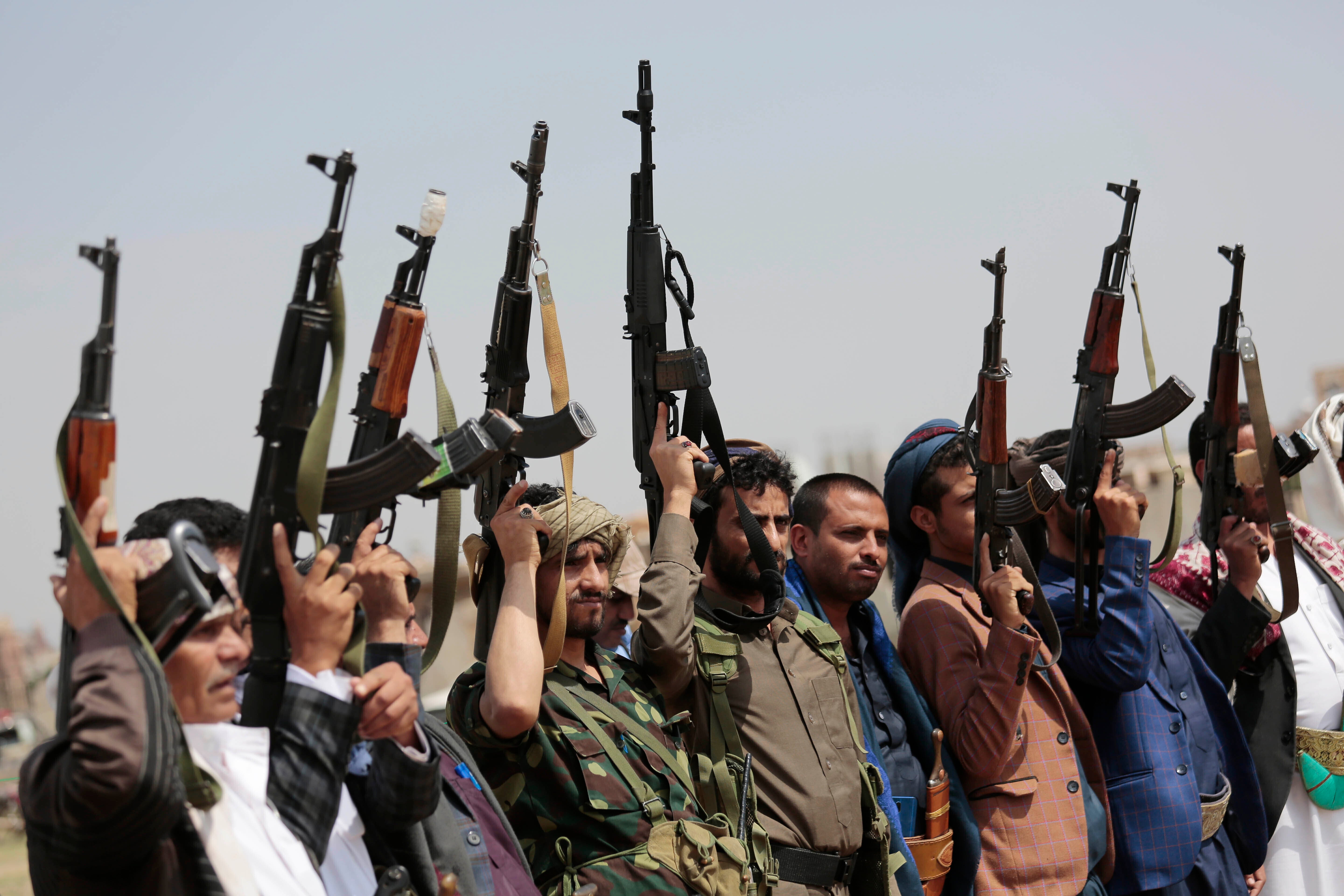 Tribesmen loyal to Houthi rebels raise their weapons during a gathering