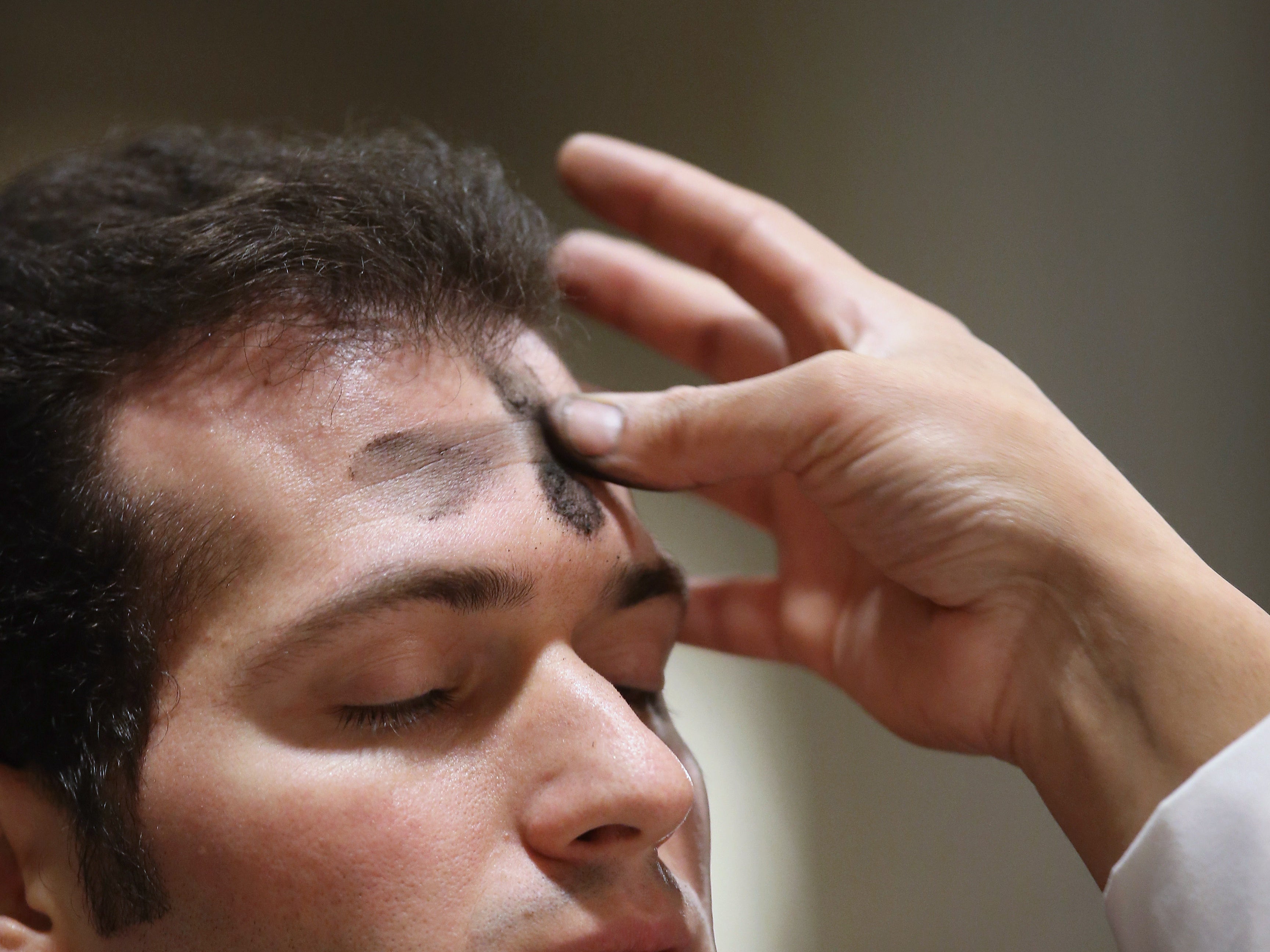 A Catholic receives ashes on his forehead while celebrating Ash Wednesday