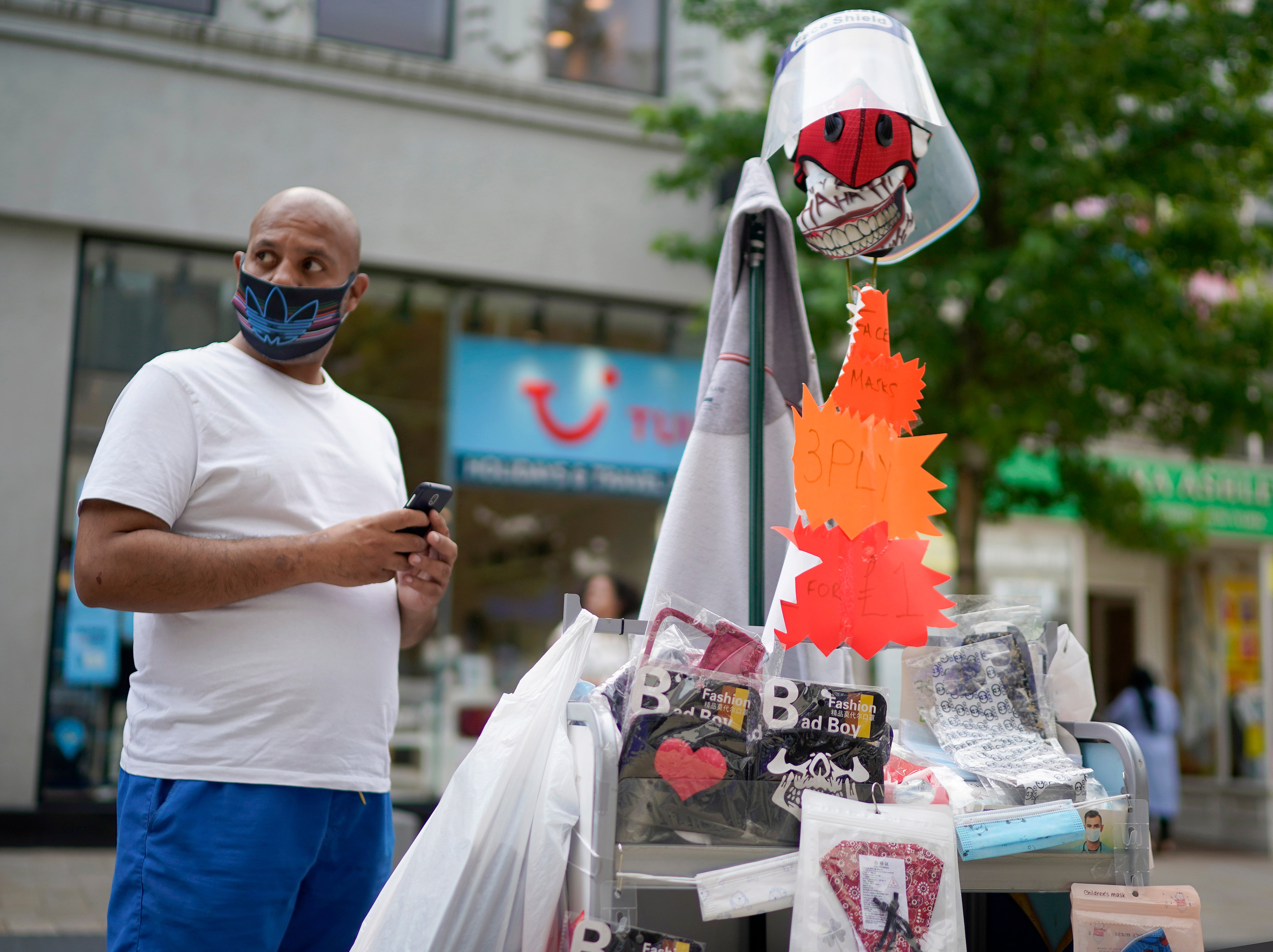 A street vendor selling domestic masks and visors works in Preston town centre during the coronavirus pandemic on 10 August