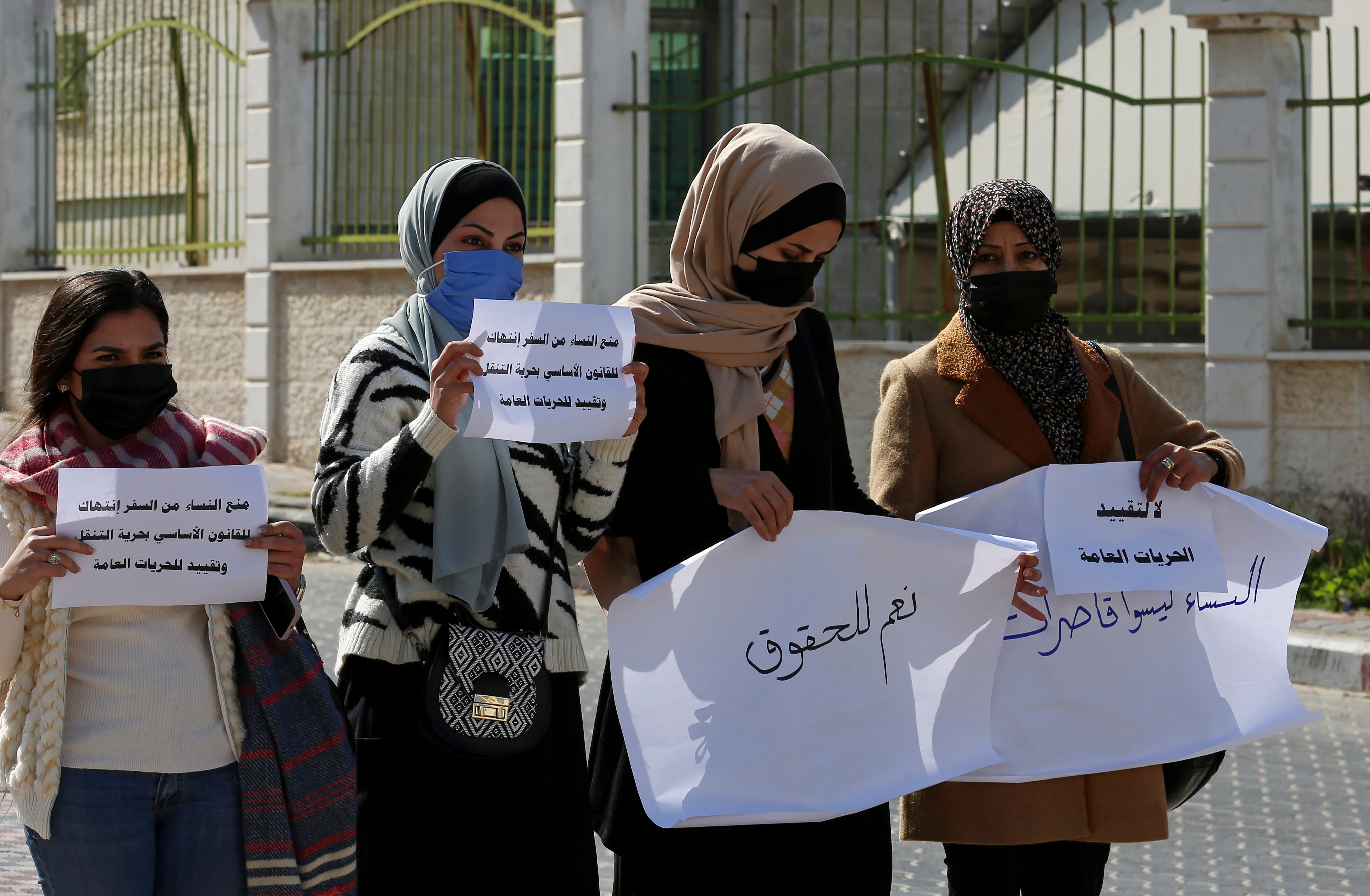 Women hold signs during a protest against the decision by the Sharia Judicial Council banning women from movement in and out of the Gaza Strip without the permission of her “guardian"