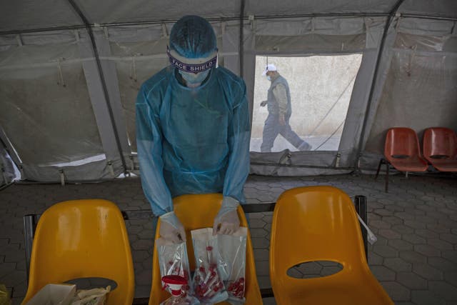 A Palestinian health worker arranges swab samples collected to test for Covid-19 in Rafah in the southern Gaza Strip