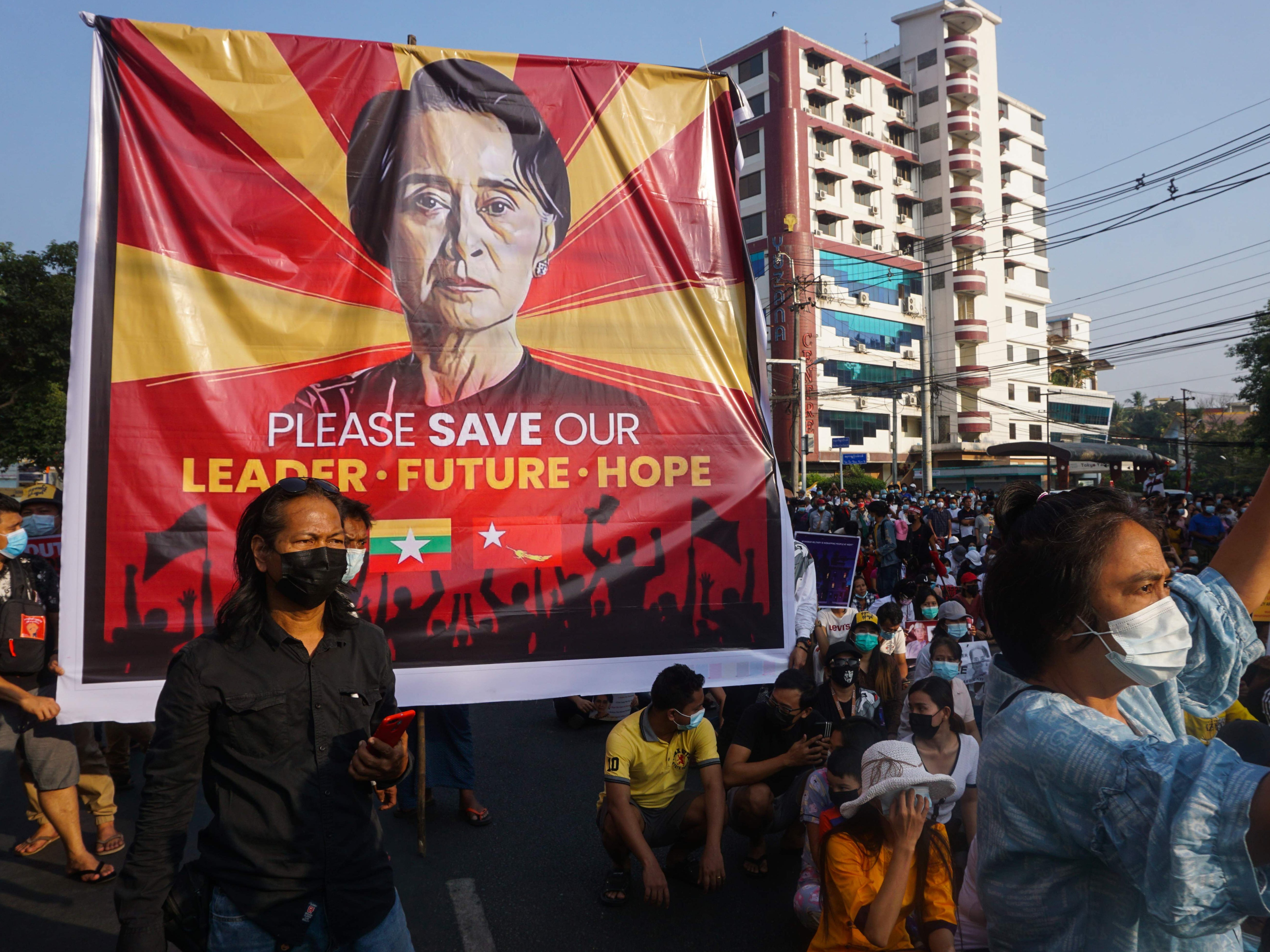 <p>A banner featuring Aung San Suu Kyi is displayed as protesters take part in a demonstration against the military coup in front of the National League for Democracy (NLD) office in Yangon</p>