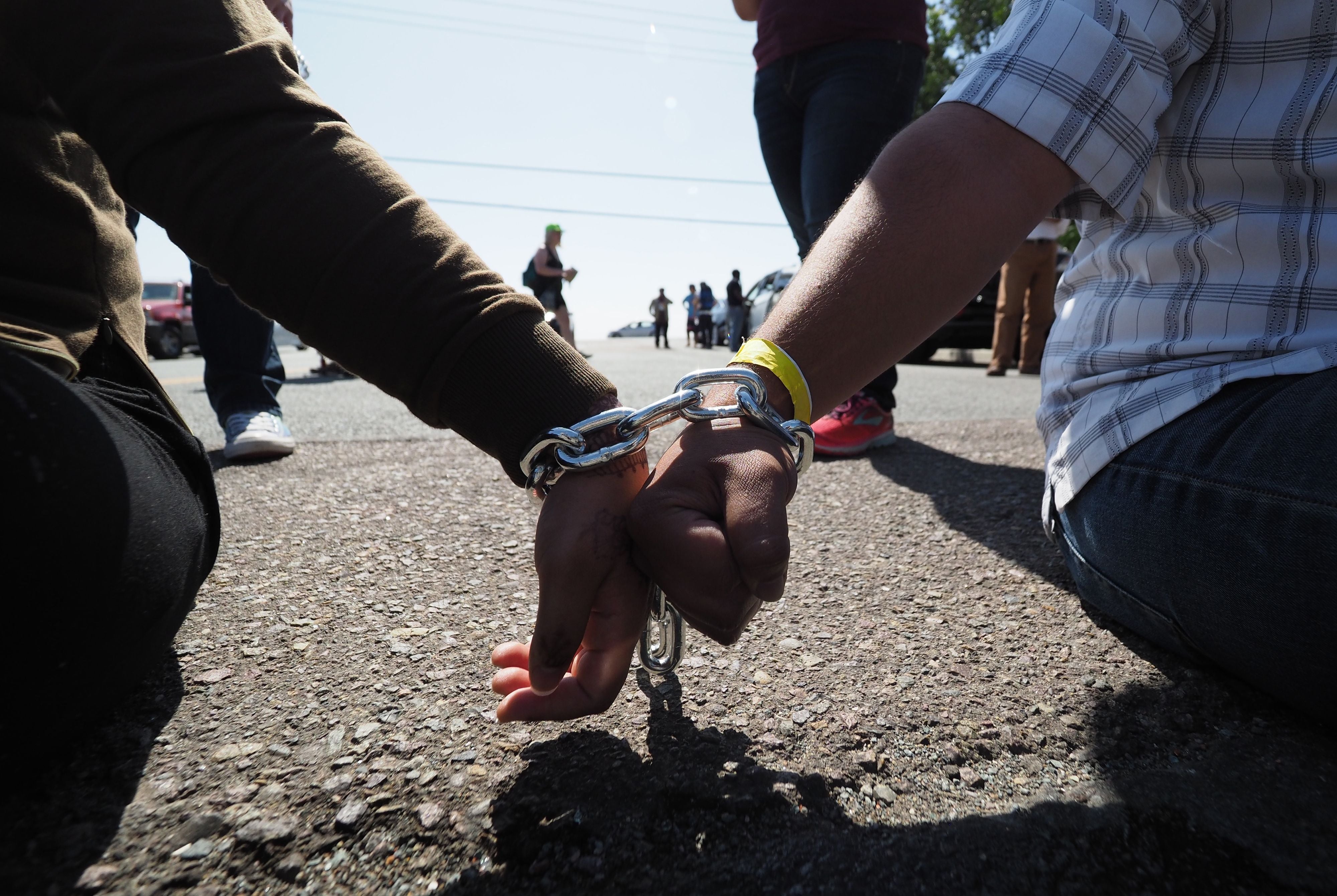 Protestors chained together at the wrist block traffic from passing on the road to the Otay Mesa Detention Center during a demonstration against US immigration policy that separates children from parents, in San Diego, California June 23, 2018