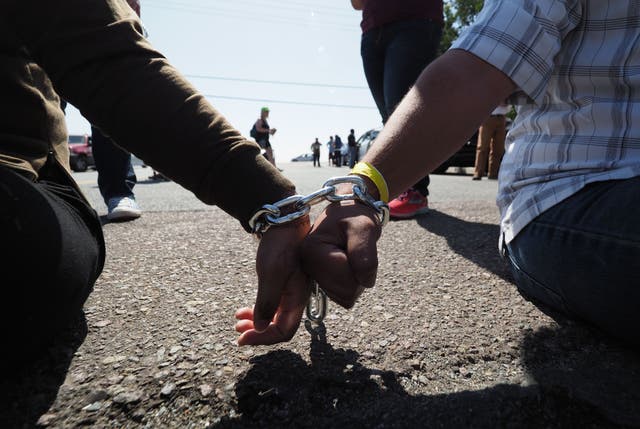 <p>Protestors chained together at the wrist block traffic from passing on the road to the Otay Mesa  Detention Center during a demonstration against US immigration policy that separates children from parents, in San Diego, California June 23, 2018</p>