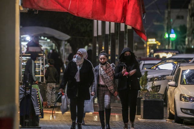 <p>Palestinians  wearing face masks in Gaza City</p>