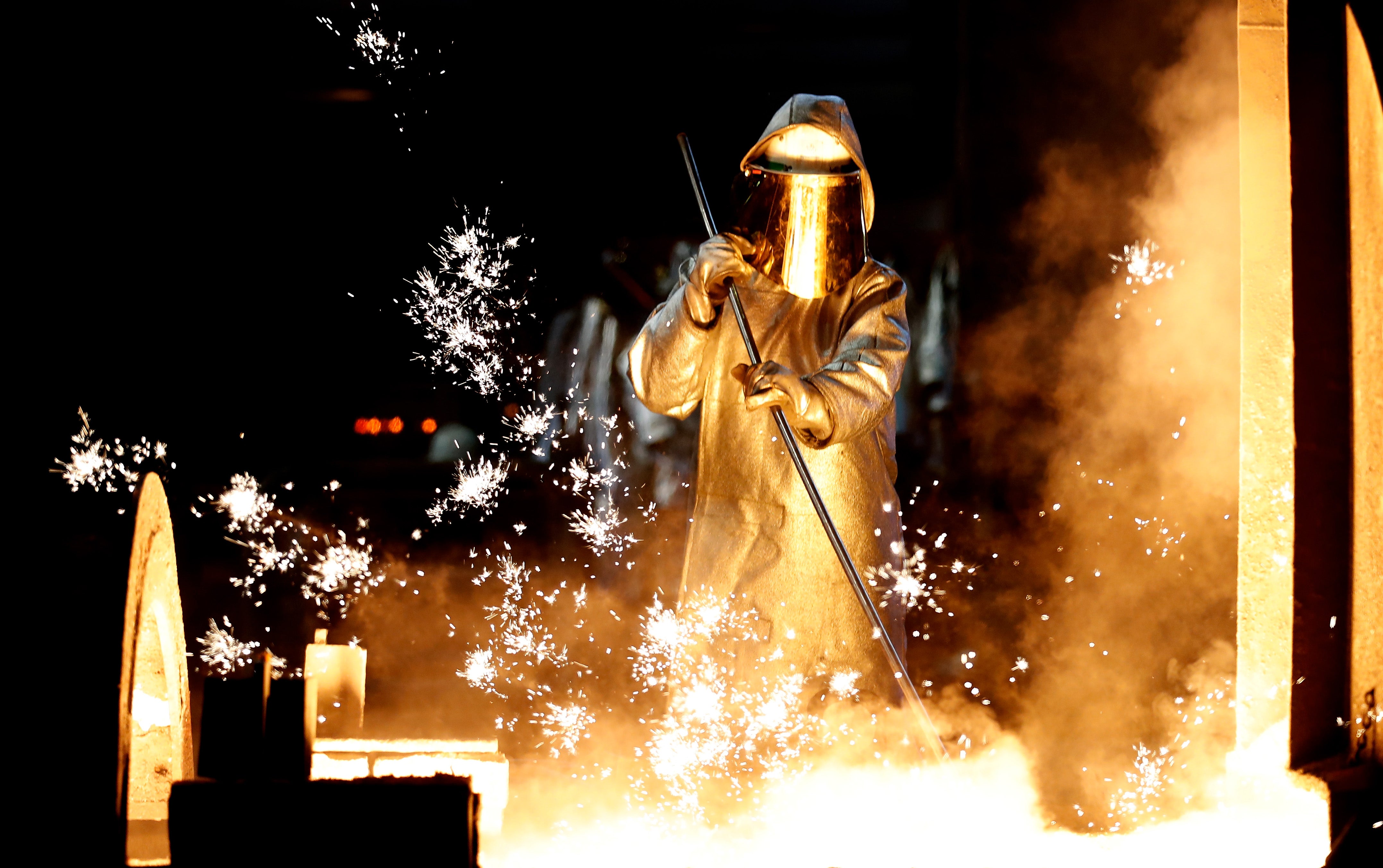 A steel worker takes a steel sample at blast furnace 8 of German corporation ThyssenKrupp in Duisburg, Germany