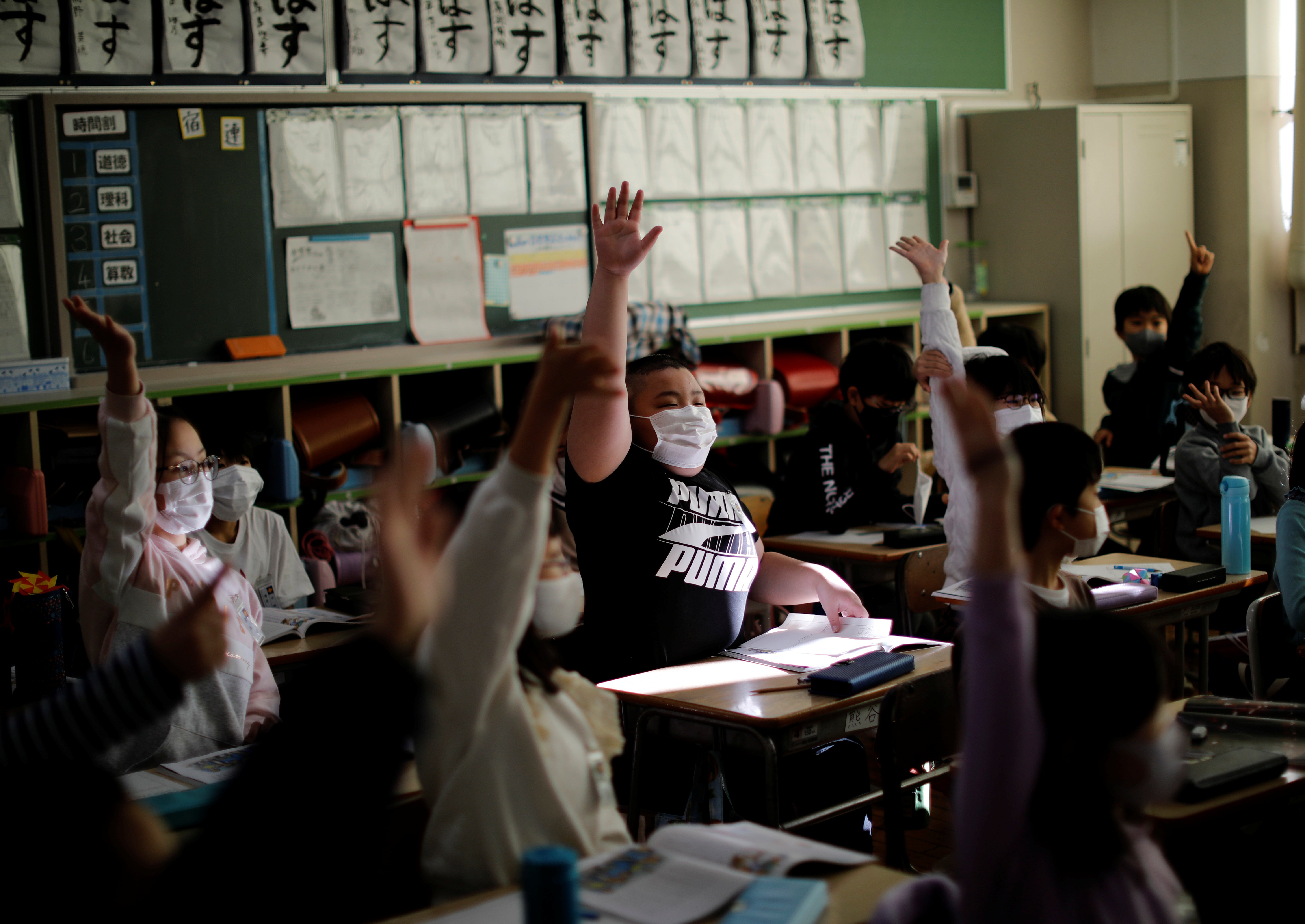 Kyuta raises his hand to answer a question at Meiji elementary school