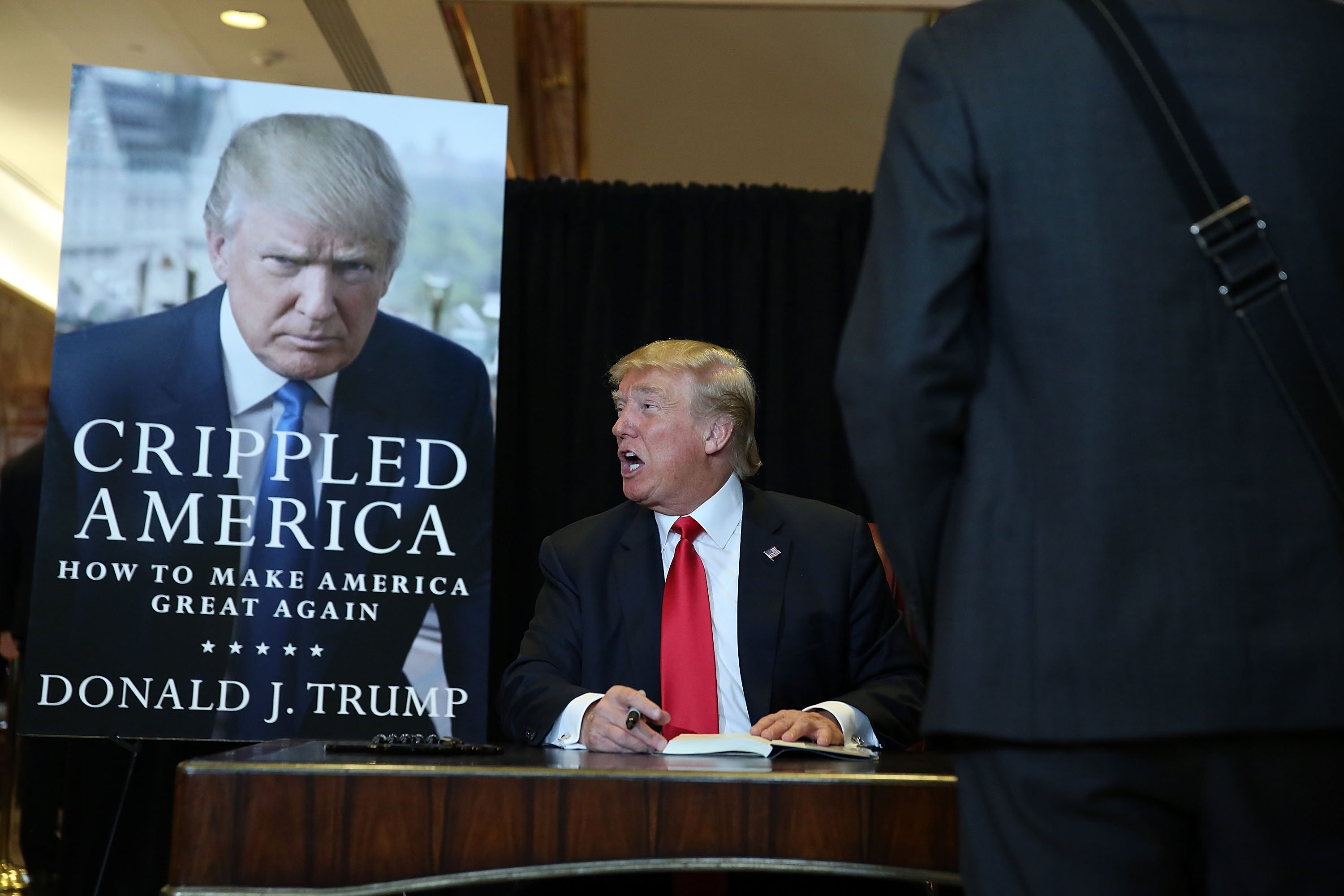 Donald Trump signs copies of his book “Crippled America: How to Make America Great Again” in 2015