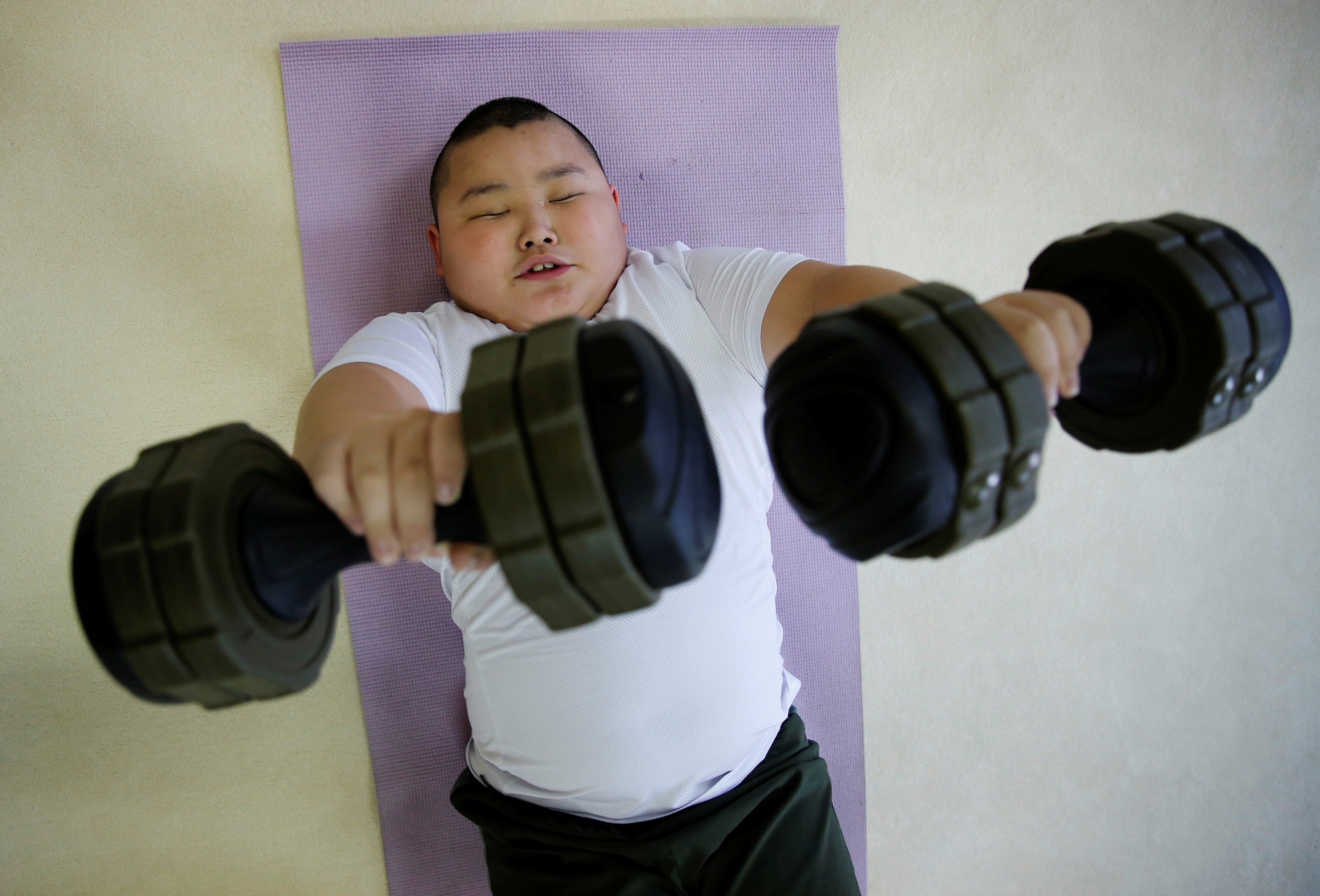 Kyuta lifts dumbbells during a one-on-one training session which his father organized at the Buddhist temple Joshin-ji