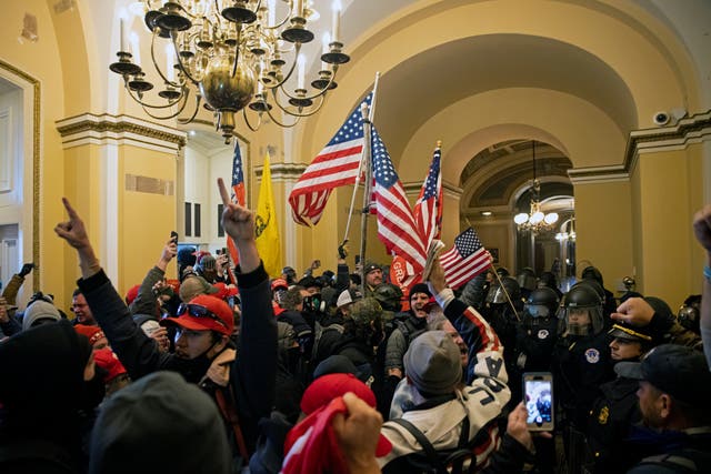<p>Supporters of Donald Trump protest inside the US Capitol on 6 January</p>