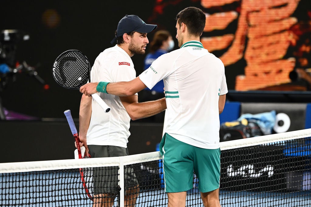 Novak Djokovic embraces Aslan Karatsev