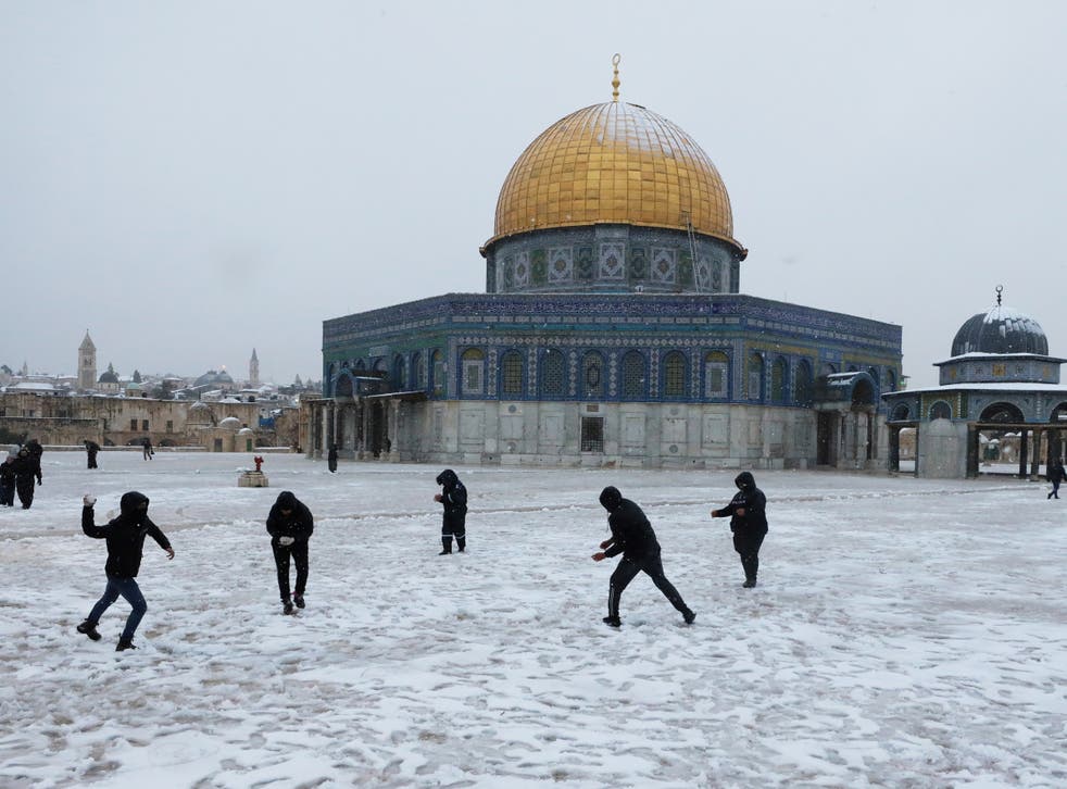 <p>People play by the Dome of the Rock on the compound known to Jews as Temple Mount and to Muslims as Noble Sanctuary during a snowy morning in Jerusalem's Old City</p>