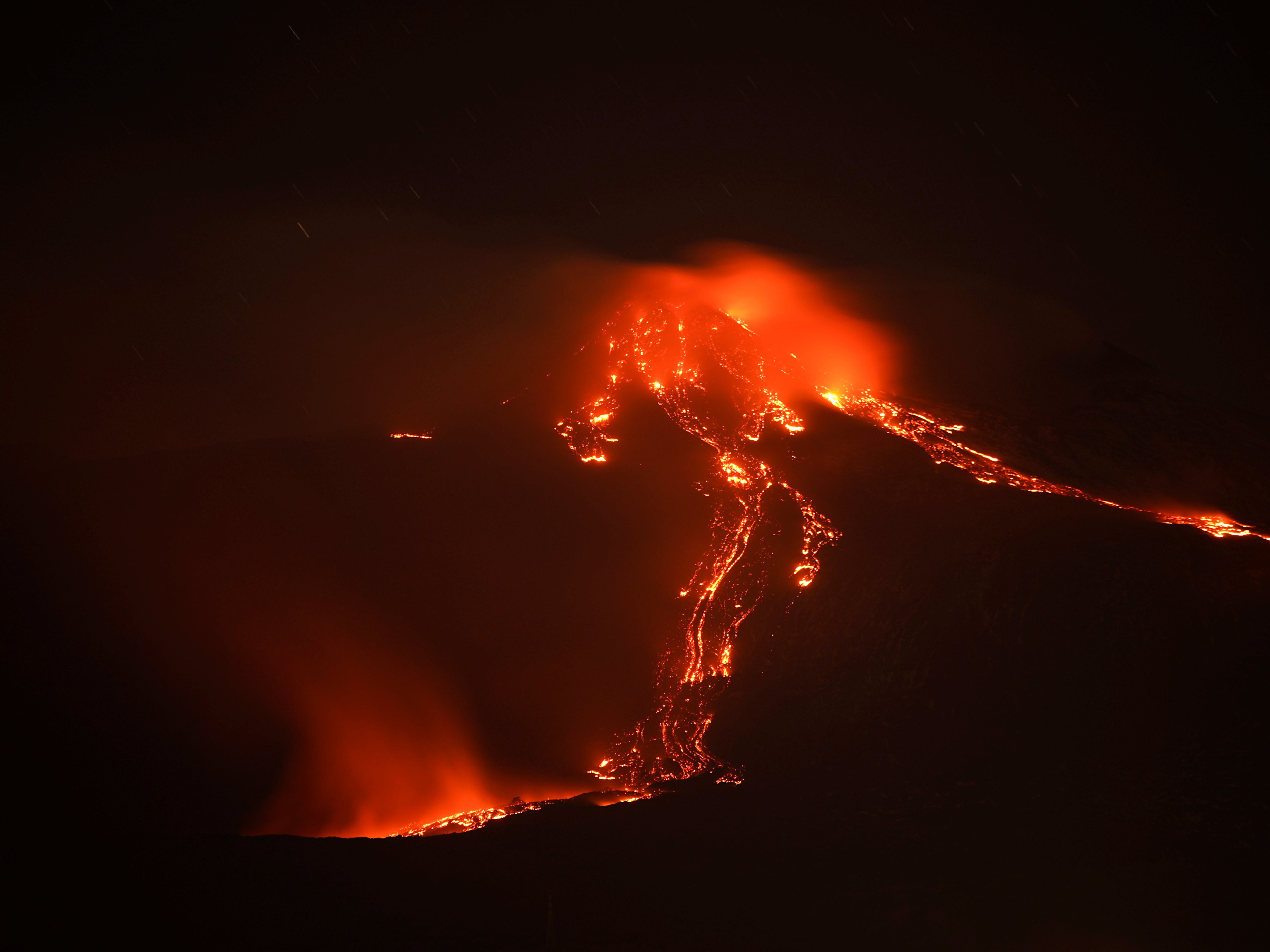 Streams of red hot lava flow as Mount Etna, Europe's most active volcano, leaps into action, seen from Giarre