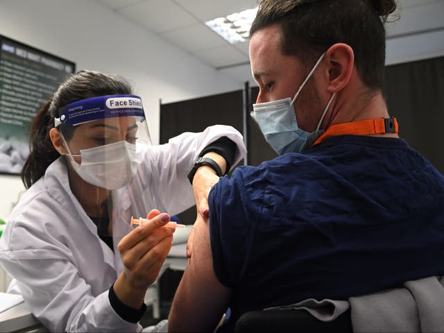 Care worker Jordan Lewis receives the Oxford-AstraZeneca Covid-19 vaccine at the Med Mart pharmacy