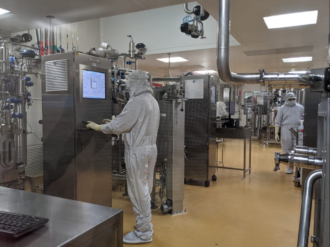 Workers monitor the progress of the vaccine inside the highly protected manufacturing unit