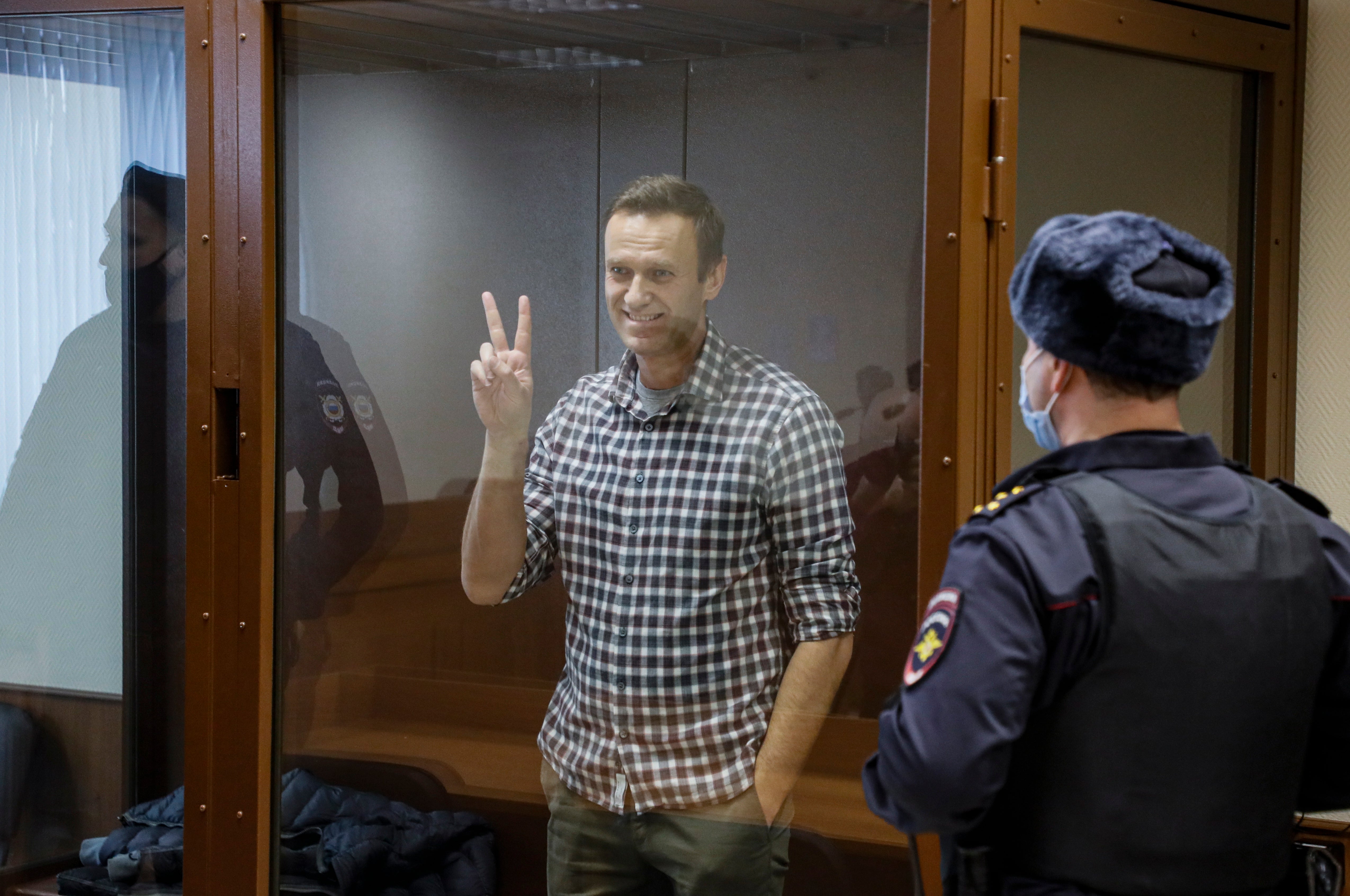 Mr Navalny, gesturing inside a glass cage prior to Saturday’s hearing at the Babushkinsky district court in Moscow, called the charges ‘absurd’