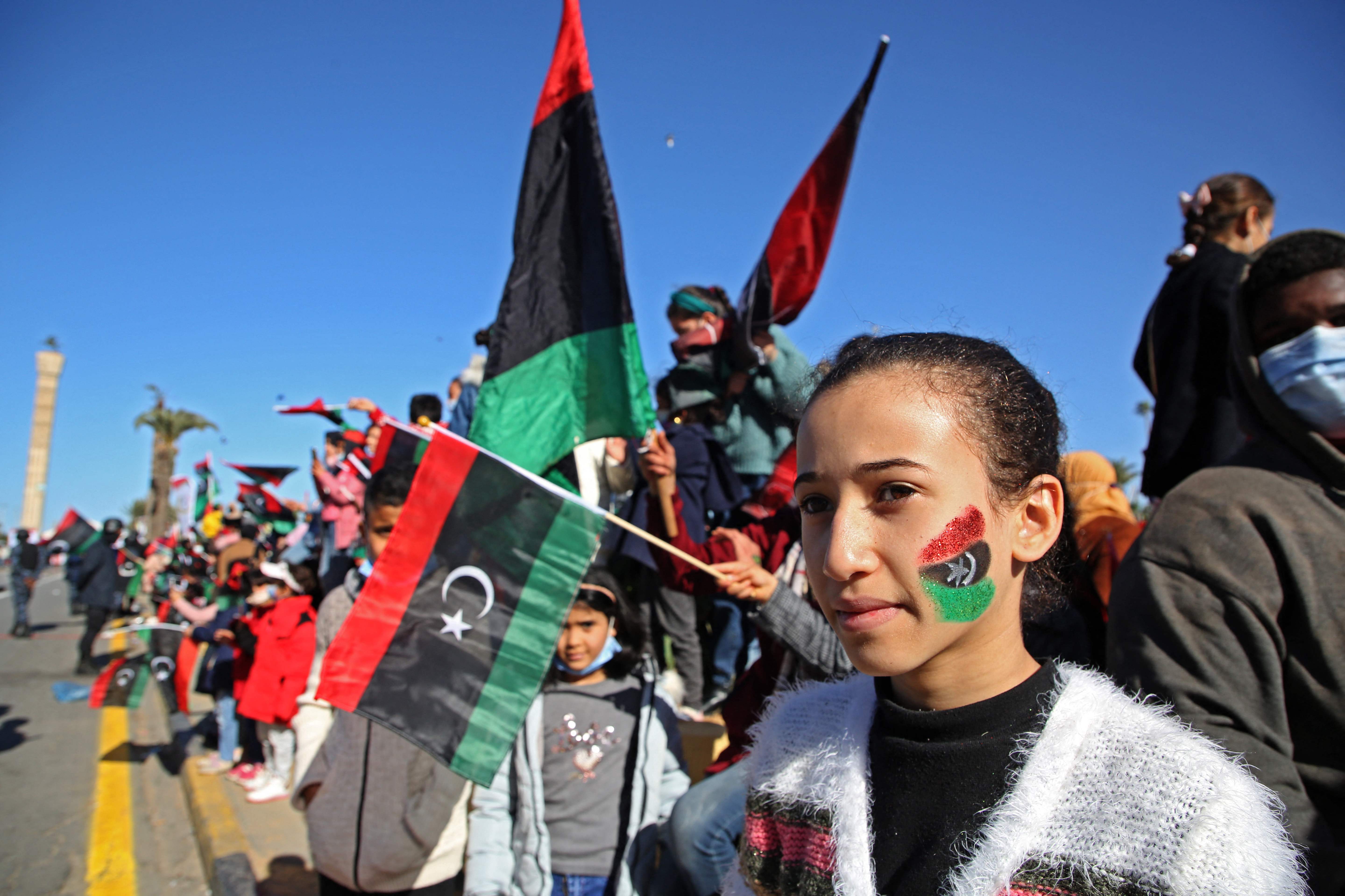 Libyans wave national flags as they gather in the capital Triploli’s Martyr’s Square to celebrate the 10th anniversary of the 2011 revolution earlier this month