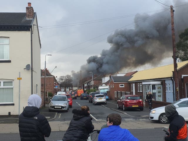 Smoke rises from the third-storey warehouse in Holland Street, Denton, Manchester