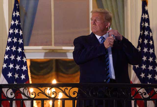 <p>File Image: In this file photo taken on 5 October, 2020, US president Donald Trump takes off his face mask as he arrives at the White House upon his return from Walter Reed Medical Center, where he underwent treatment for Covid-19</p>