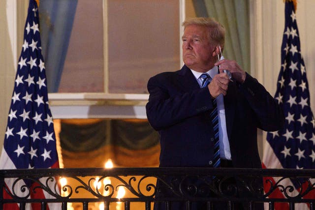 <p>File Image: In this file photo taken on 5 October, 2020, US president Donald Trump takes off his face mask as he arrives at the White House upon his return from Walter Reed Medical Center, where he underwent treatment for Covid-19</p>