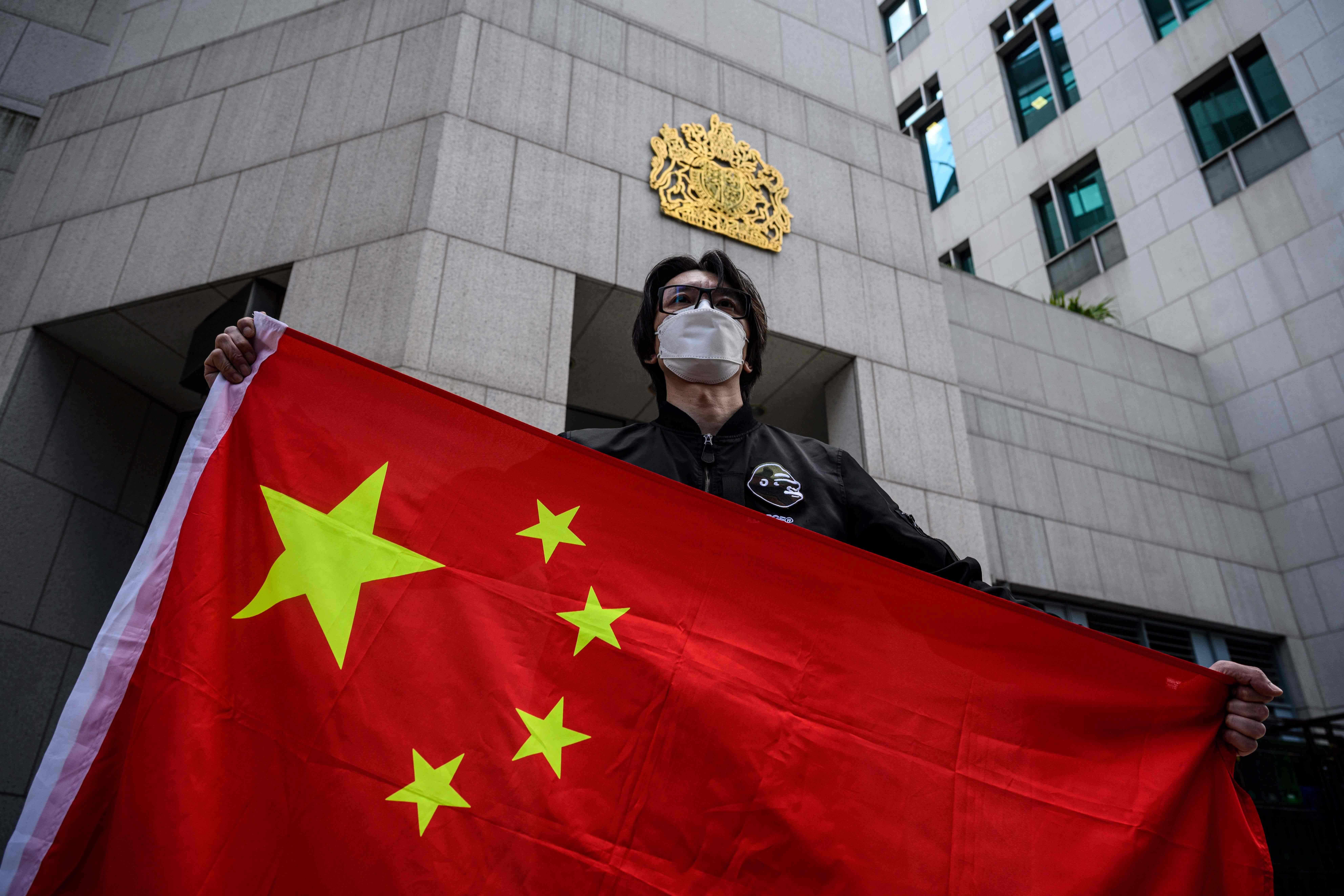 A man holds the national flag of China after a pro-Beijing activist group gathered outside the British Consulate-General to protest against the use of the British National (Overseas) passport in Hong Kong