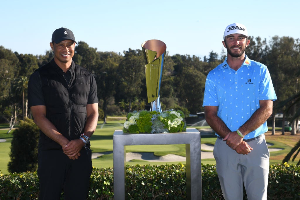 Max Homa stands with the trophy and tournament host Tiger Woods