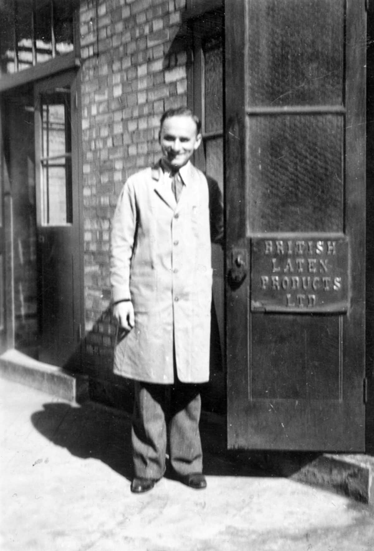 Lucian Landau, the inventor of Durex condoms, at the entrance to British Latex Products, 1932