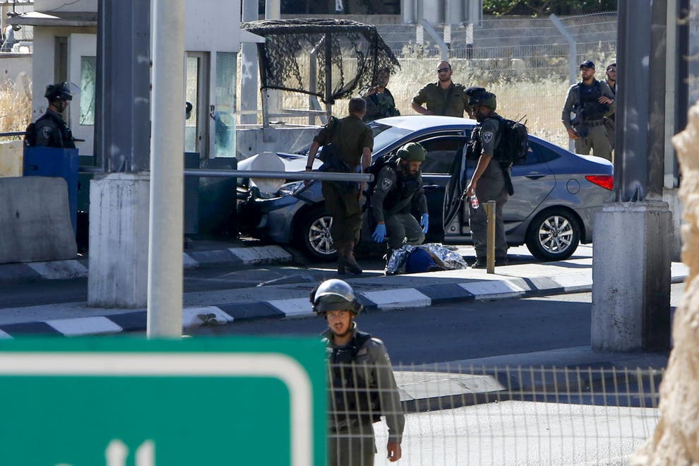 Israeli forces cover the body of Ahmed Erekat