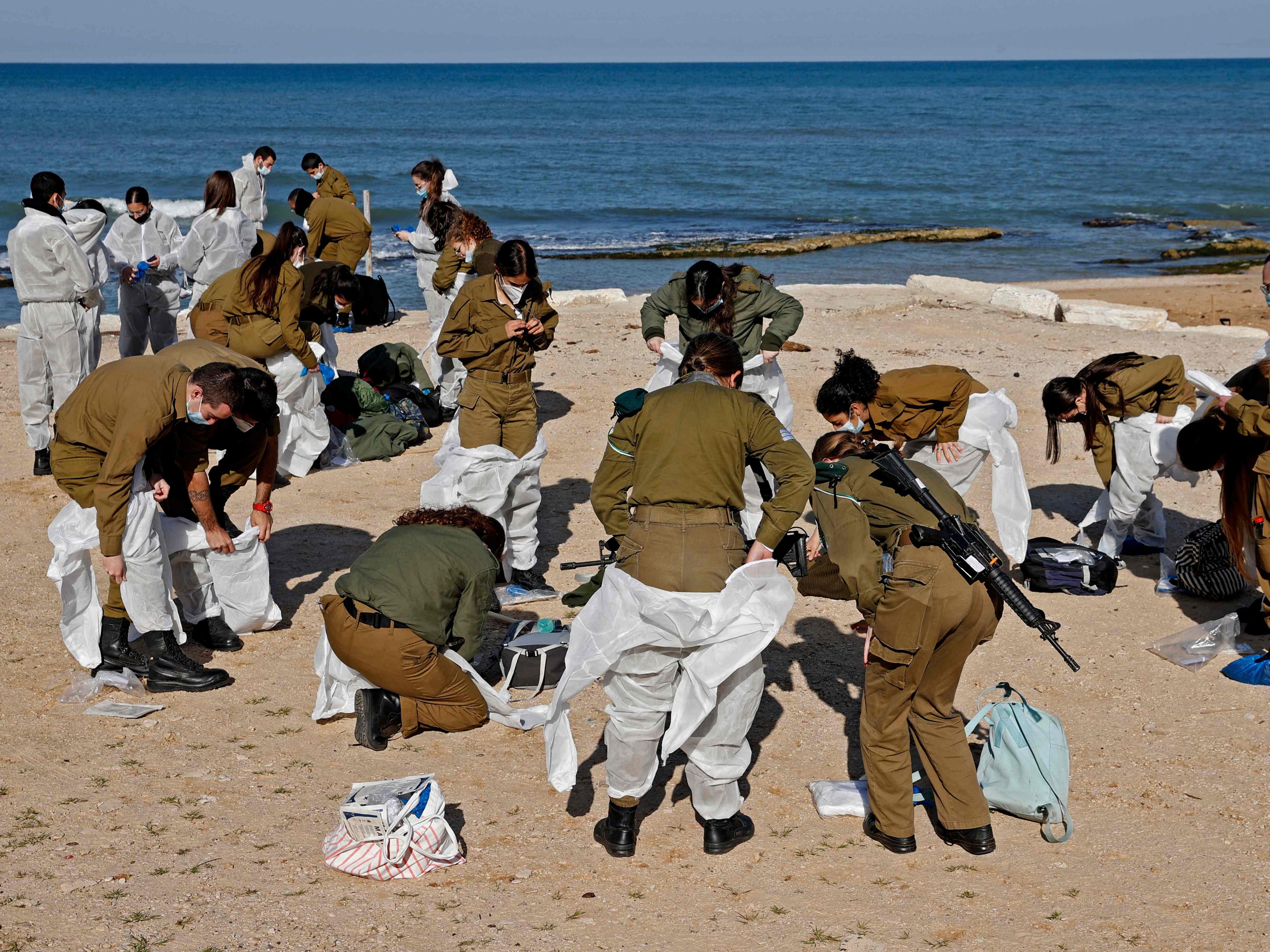 Israeli soldiers arrive to clean up the contaminated Sharon beach national park, north of Tel Aviv city, on February 22 2021