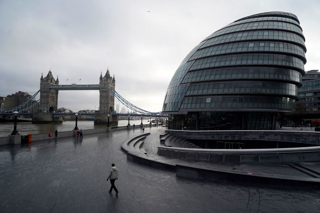 Quiet: a handful of pedestrians walk near Tower Bridge in central London