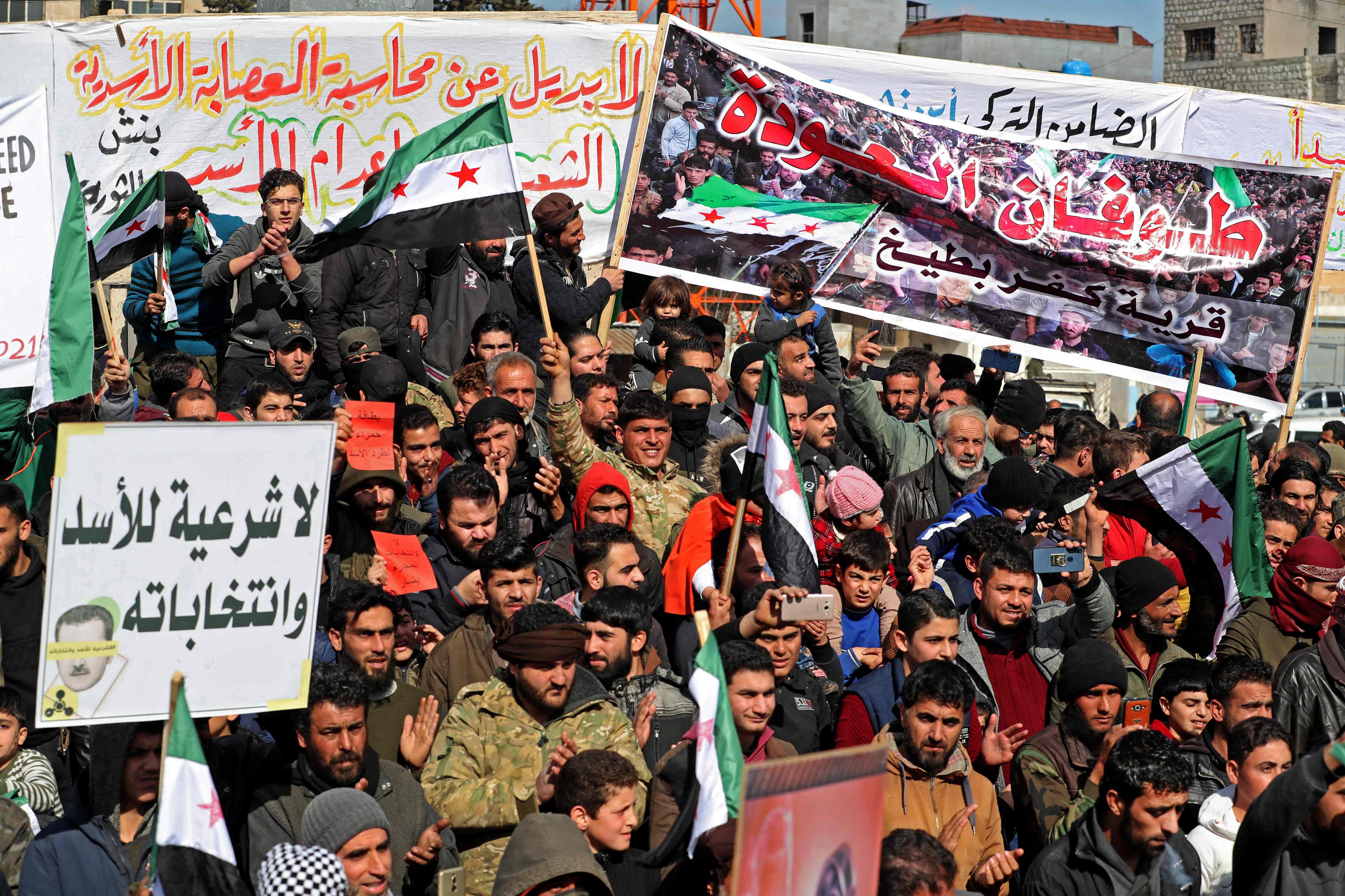 Displaced Syrians demonstrate against President Bashar al-Assad and the upcoming presidential election in the rebel-held city of Idlib on February 19, 2021