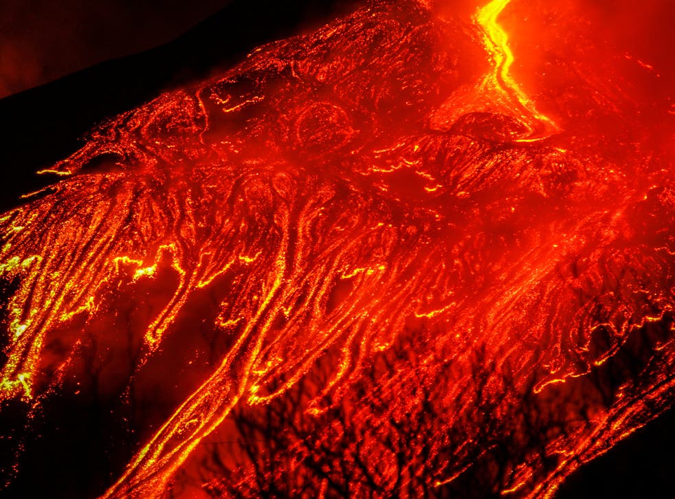 Large streams of red hot lava flow as Mount Etna, Europe's most active volcano, leaps into action, as seen from the village of Fornazzo