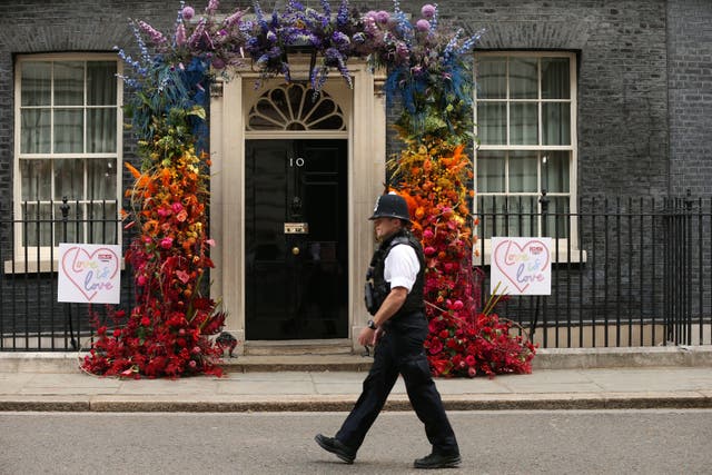 A police man walks past a floral LGBT+ decoration outside 10 Downing Street after a Pride reception held by the former prime minister, Theresa May in 2019