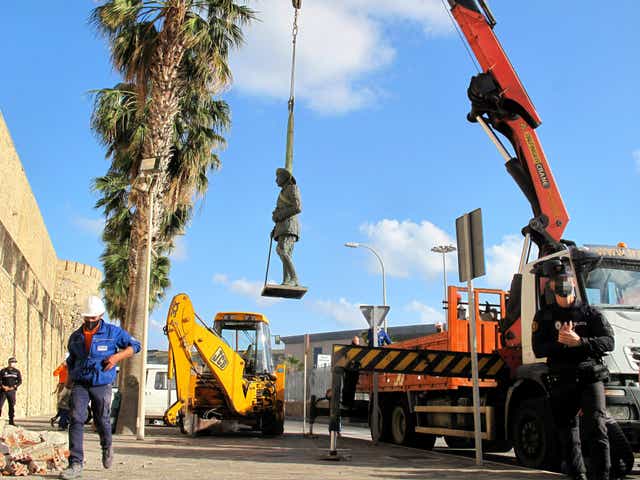 A crane removes the statue of Franco located in front of the wall of Melilla’s old town
