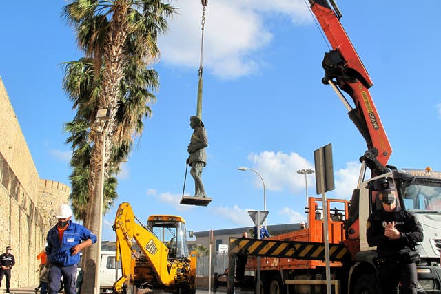 A crane removes the statue of Franco located in front of the wall of Melilla’s old town