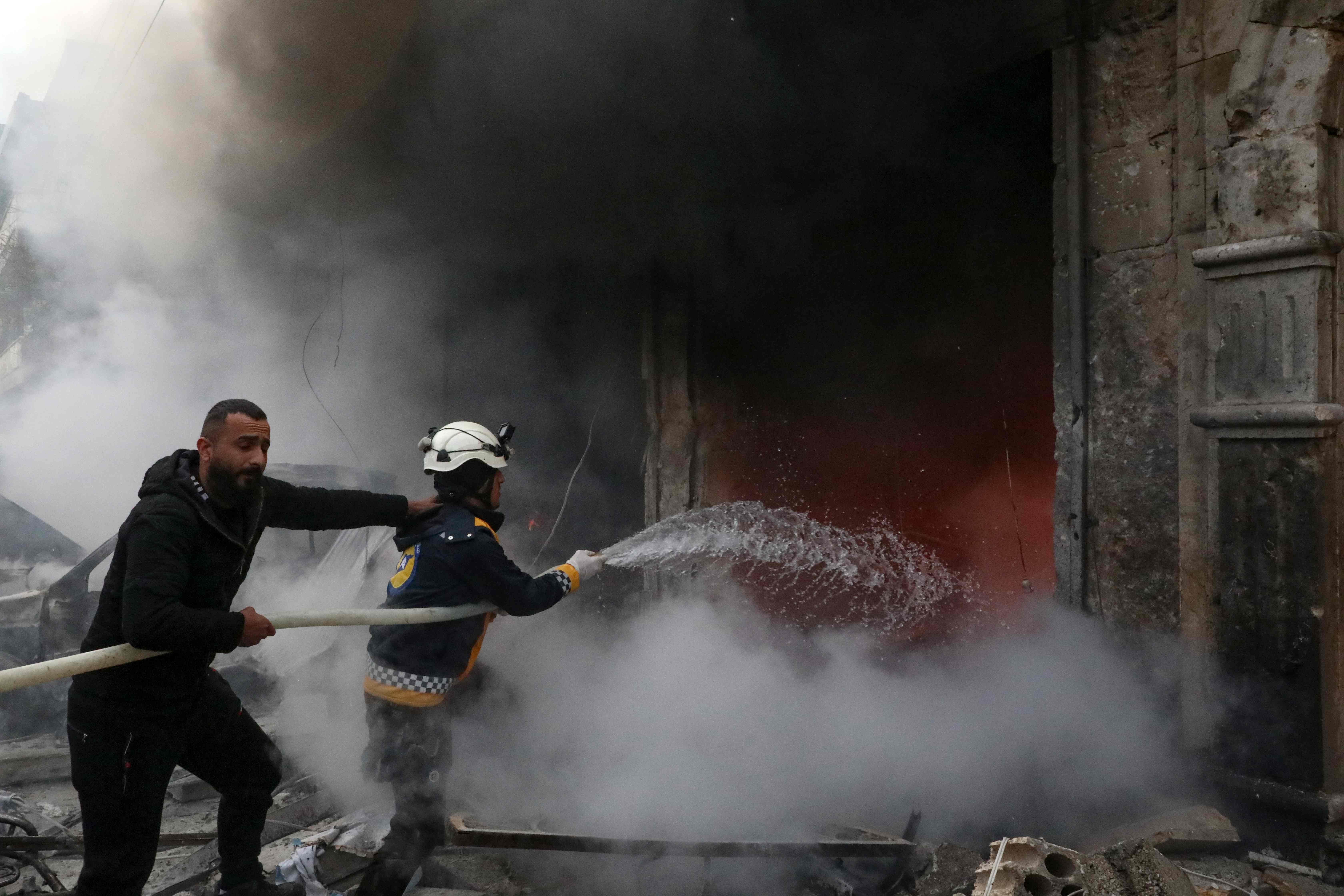 Rescue workers extinguish a fire cause by an explosion in the town of Azaz